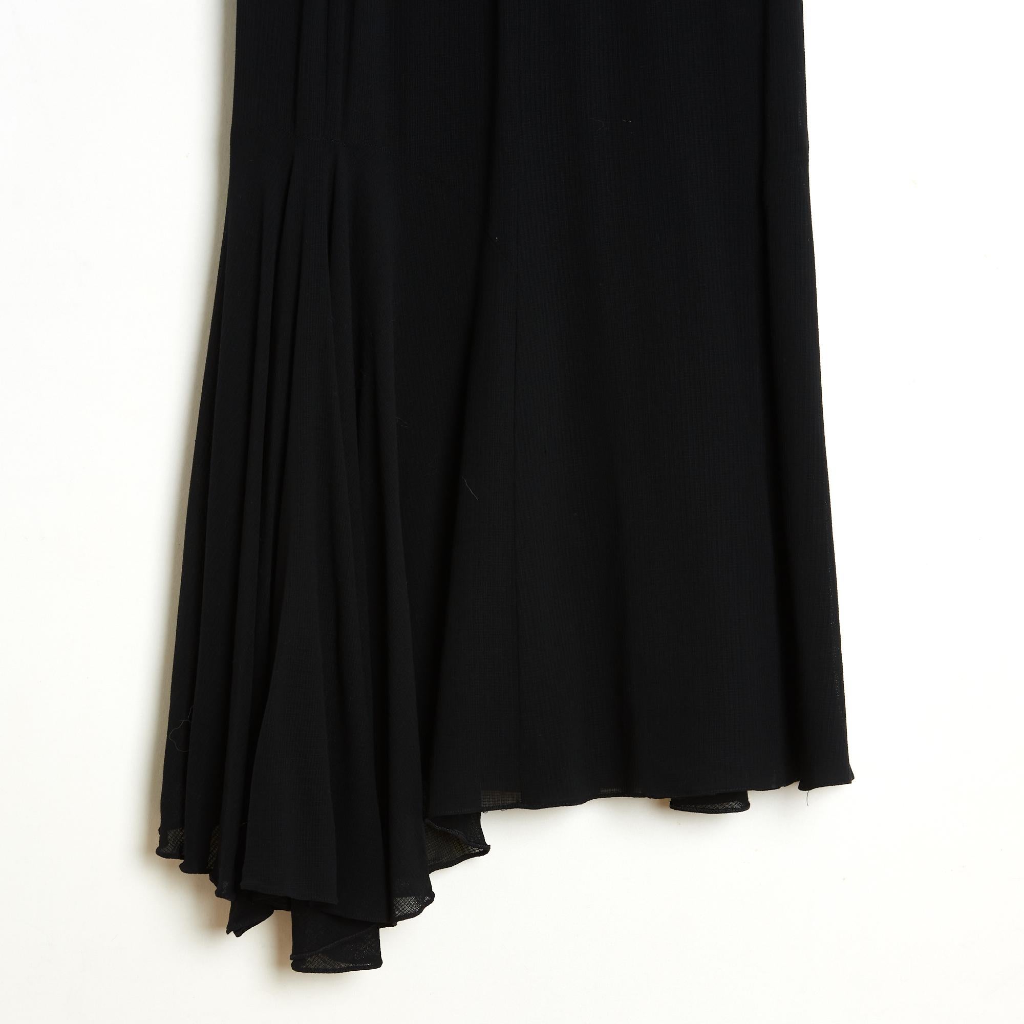 Chanel maxi skirt circa 1992 in black wool twill, high-waisted, fitted to the knees and flared—almost ruffled—at the hem, lined in black silk crepe, fastens with a button and zip. The composition and size labels are missing, but the measurements