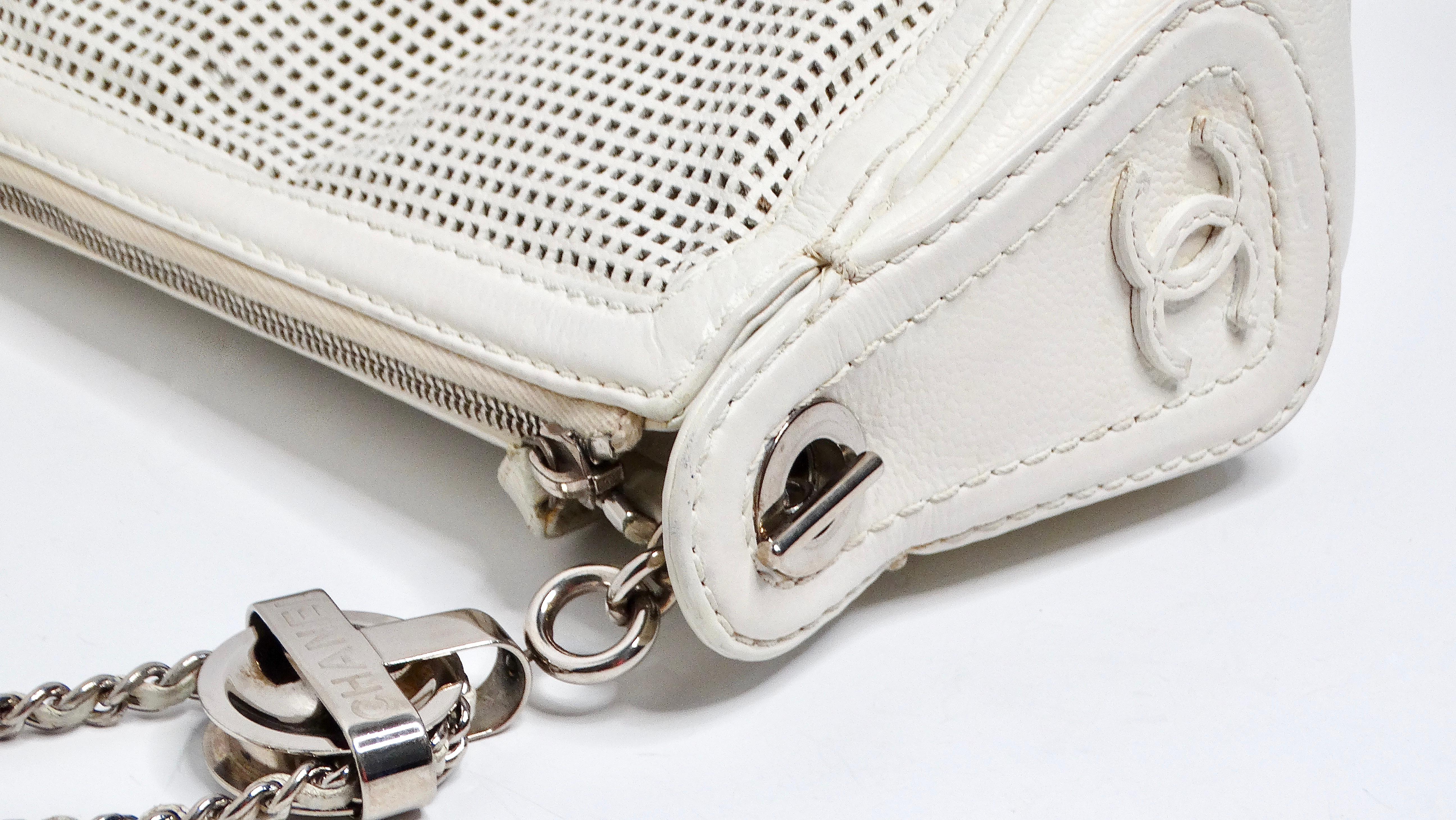 
The Chanel Y2K Perforated White Leather Pulley Shoulder Bag, circa 2004-2005, is an iconic piece that captures the essence of early 2000s fashion. Designed under the visionary creative direction of Karl Lagerfeld, this bag features silver hardware,