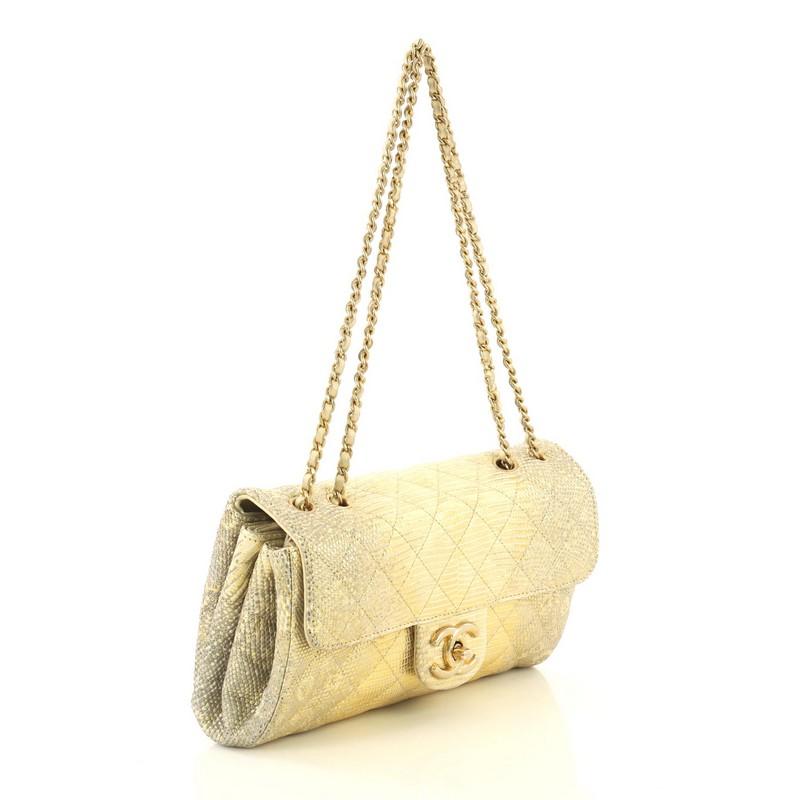 This Chanel Clams Pocket Flap Bag Quilted Lizard Medium, crafted from genuine gold quilted lizard, features woven-in leather chain strap, frontal flap, and gold-tone hardware. Its CC turn-lock closure opens to a neutral leather interior showcasing
