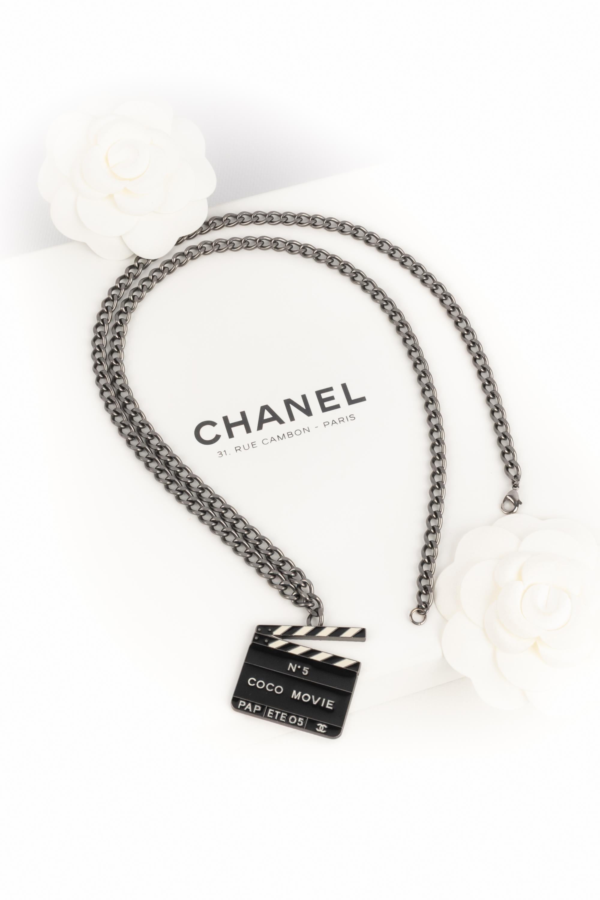 Chanel - (Made in France) Collana in metallo argentato scuro con ciondolo a forma di ciak. Collezione Primavera-Estate 2005 sotto la direzione artistica di Karl Lagerfeld.

Condizioni:
Ottime condizioni

Dimensioni:
Lunghezza: 82 cm - Ciondolo: 4 cm