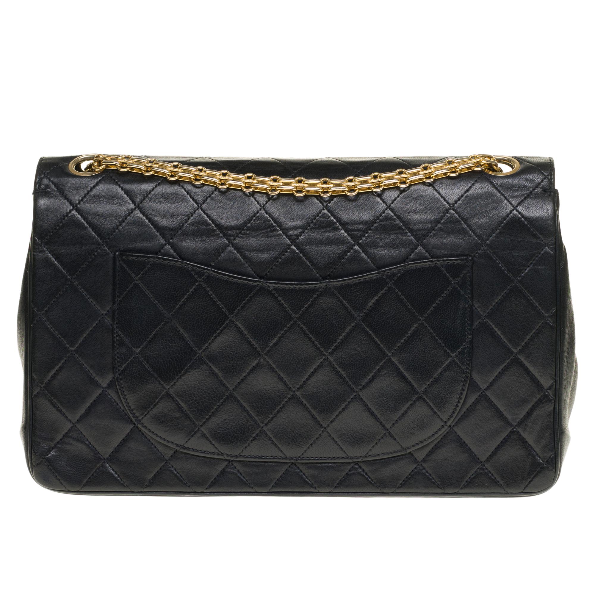 Beautiful Chanel Timeless Handbag 27cm with double flap in black quilted lambskin leather, gold metal trim, a Mademoiselle chain handle in gold metal allowing a hand or shoulder support.

Closure with gold metal flap.
A patch pocket on the back of
