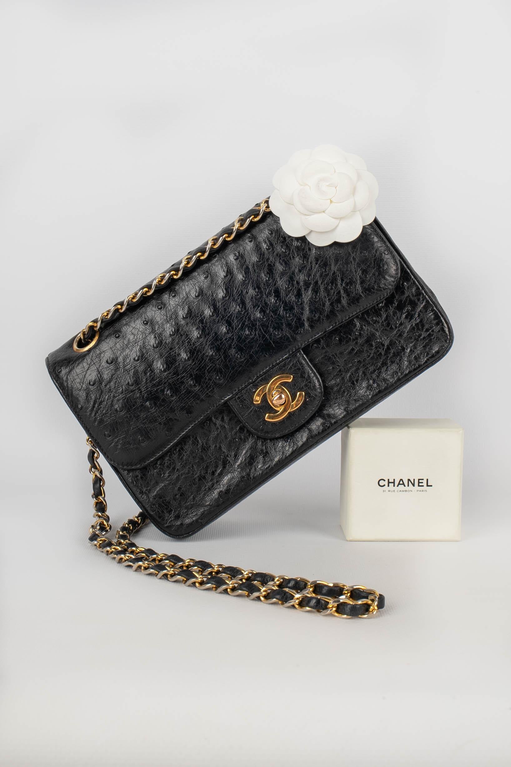 CHANEL - (Made in France) Black ostrich leather classic bag with a gold-plated cc fastener on a double flap, adjustable chain handle interlaced with leather. Bag with a serial number and a certificate of conformity. 1996/1997