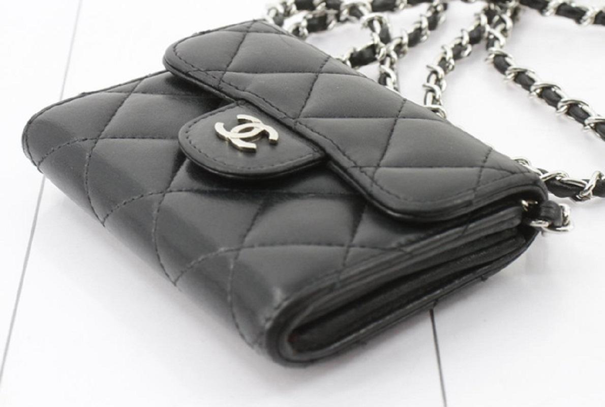 Chanel classic crossbody bag features black quilted leather, silver-tone hardware, a detachable intertwined leather and chain shoulder strap, interlocking CC logo at front flap, slip pocket at back, burgundy canvas lining with two main compartments