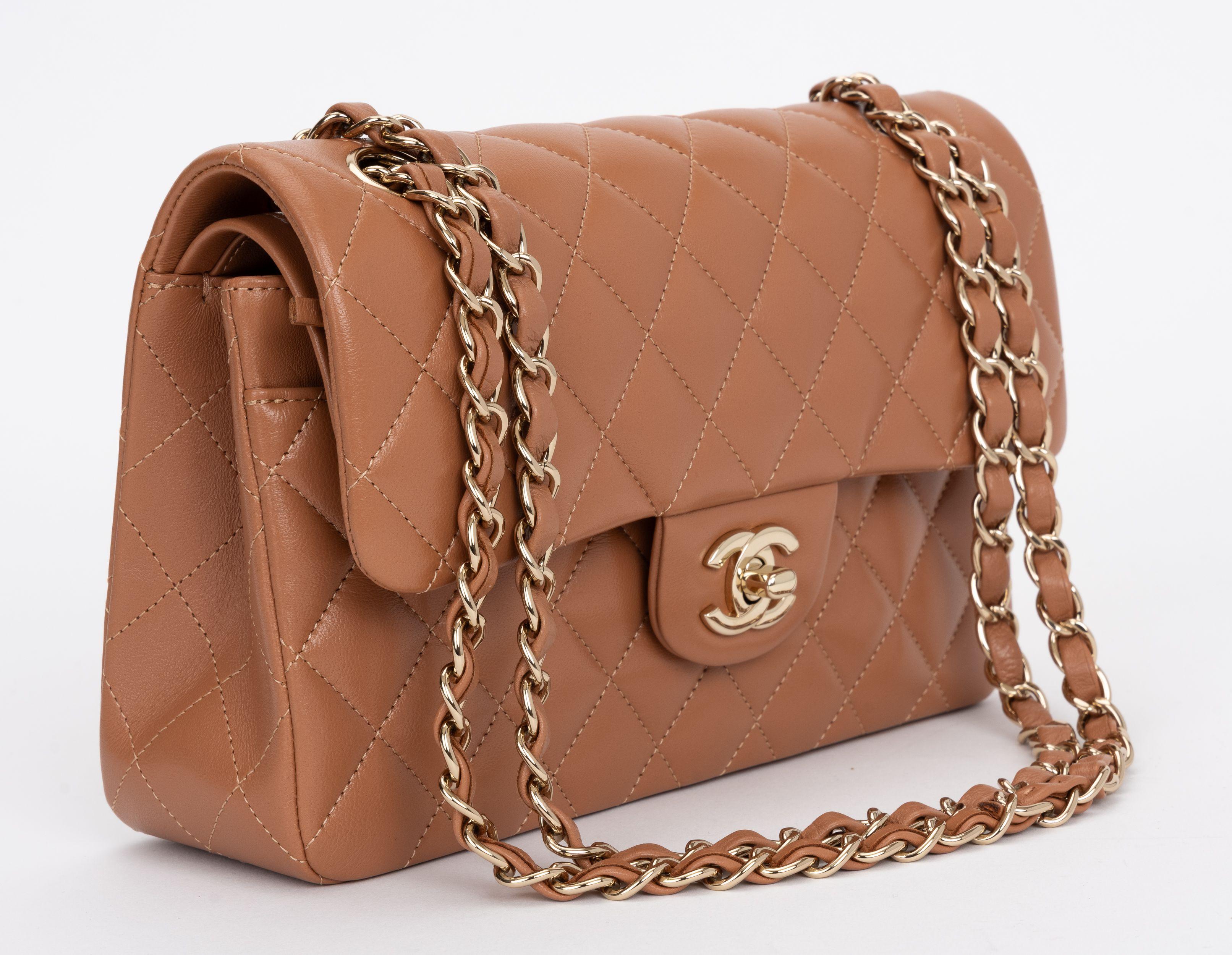 The Chanel Classic Double Flap in Caramel Lambskin with Gold Hardware features a CC Turlock closure, exterior back pocket and adjustable interwoven gold chain link strap. One zipper pocket in the interior. Two interior open pockets. Shoulder drop