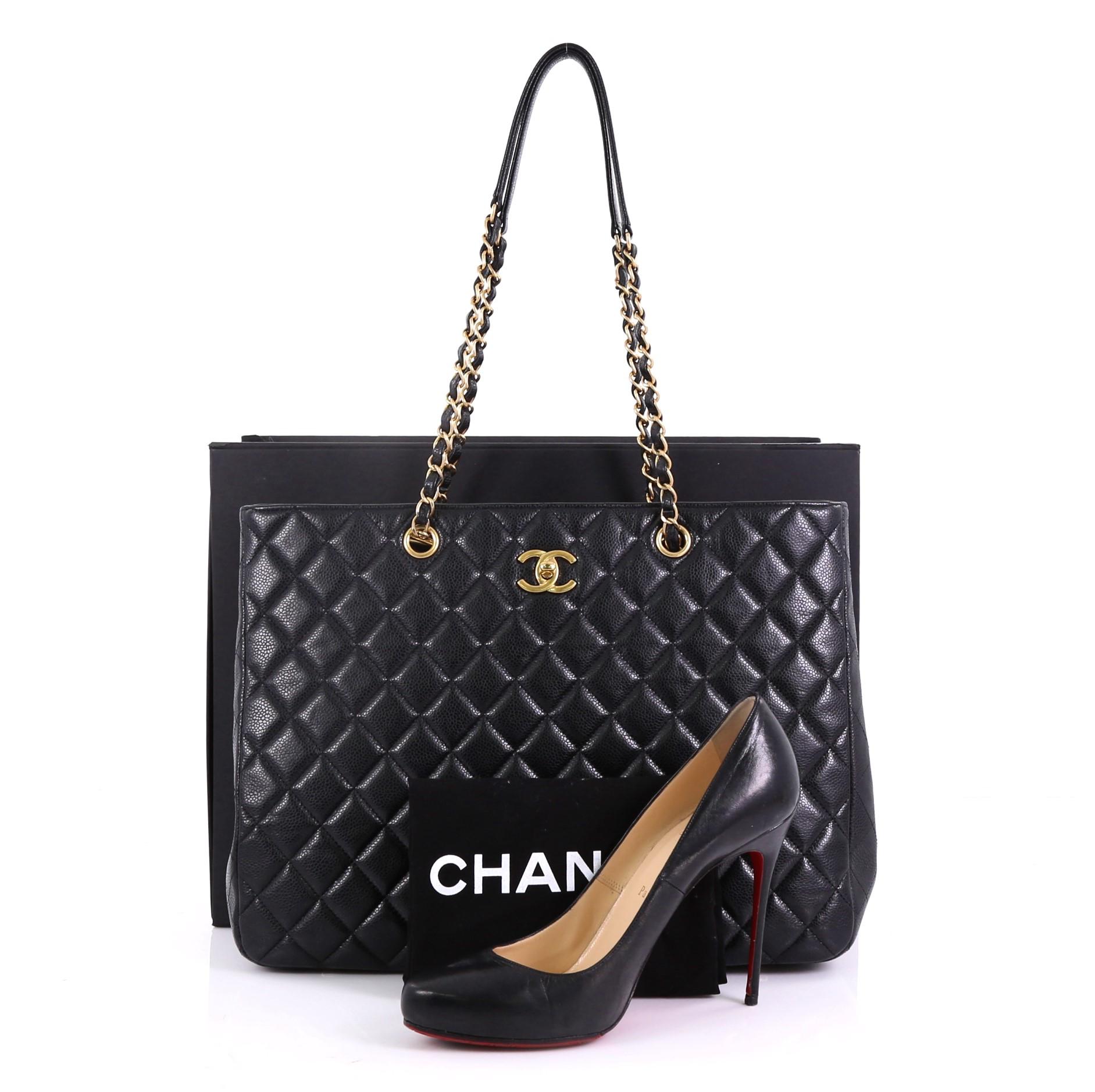 This Chanel Classic CC Shopping Tote Quilted Caviar Large, crafted in black quilted caviar leather, features dual woven in leather chain straps with leather pads, protective base studs, and gold-tone hardware. Its CC turn-lock closure opens to a