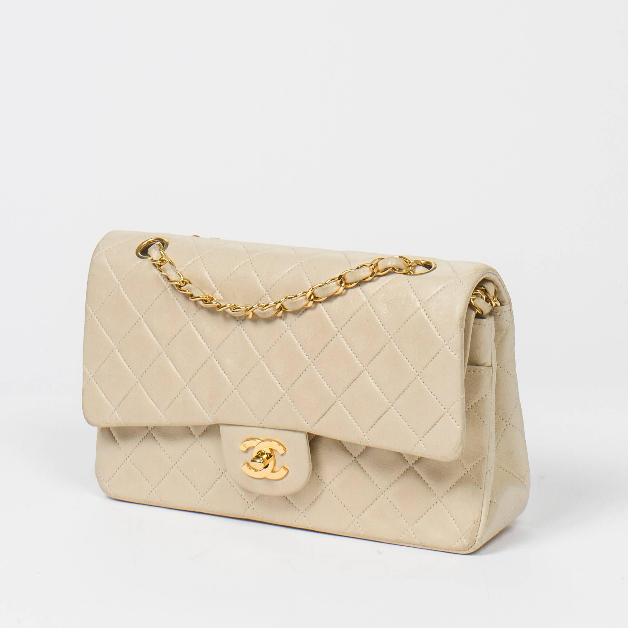 Classic Double Flap 26 in ivory quilted lambskin, double chain strap interlaced with leather, signature turnlock closure, gold tone hardware. Back slip pocket. Ivory leather lined interior with 3 slip pockets. Gold tone heat stamp 