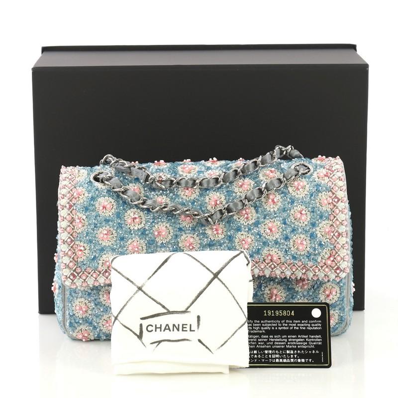 This Chanel Classic Double Flap Bag Embellished Sequins and Pearls Medium, crafted from blue and pink embellished sequins and quilted pearls, features woven-in leather chain straps, exterior back pocket, and silver-tone hardware. Its CC turn-lock