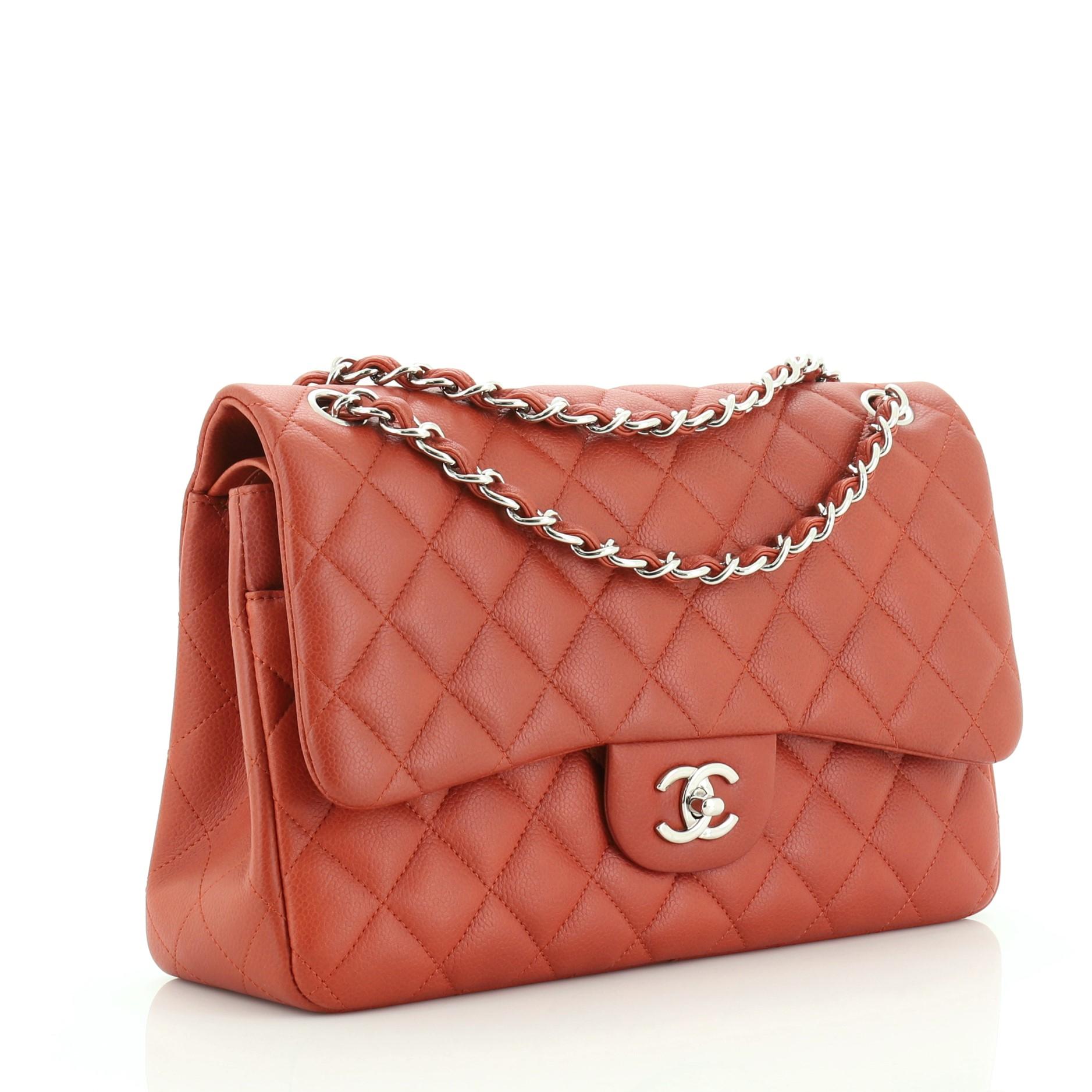 This Chanel Classic Double Flap Bag Quilted Caviar Jumbo, crafted from orange quilted caviar leather, features woven-in leather chain strap, exterior back pocket and silver-tone hardware. Its double flap and frontal CC turn-lock closure opens to an