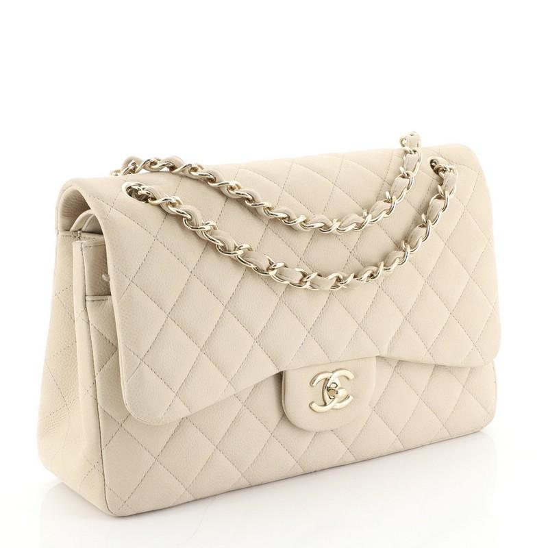 This Chanel Classic Double Flap Bag Quilted Caviar Jumbo, crafted from neutral quilted caviar leather, features woven-in leather chain strap, exterior back pocket and gold-tone hardware. Its double flap and frontal CC turn-lock closure opens to a