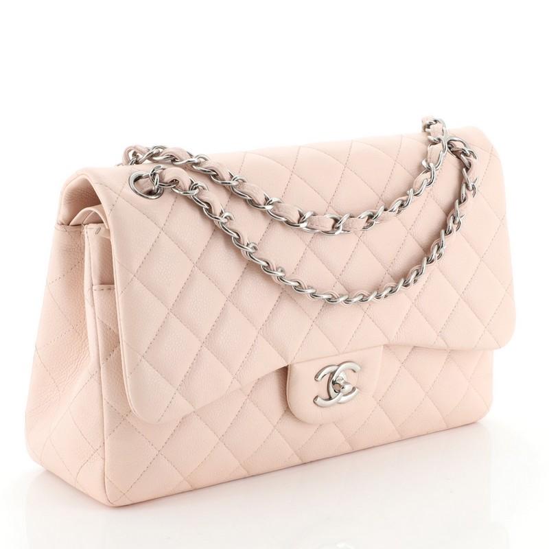 This Chanel Classic Double Flap Bag Quilted Caviar Jumbo, crafted from pink quilted caviar leather, features woven-in leather chain strap, exterior back pocket and silver-tone hardware. Its double flap and frontal CC turn-lock closure opens to a