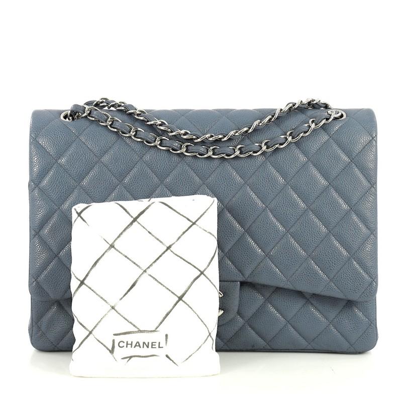 This Chanel Classic Double Flap Bag Quilted Caviar Maxi, crafted from blue quilted caviar leather, features woven-in leather chain strap, exterior back pocket and silver-tone hardware. Its double flap and frontal CC turn-lock closure opens to a blue