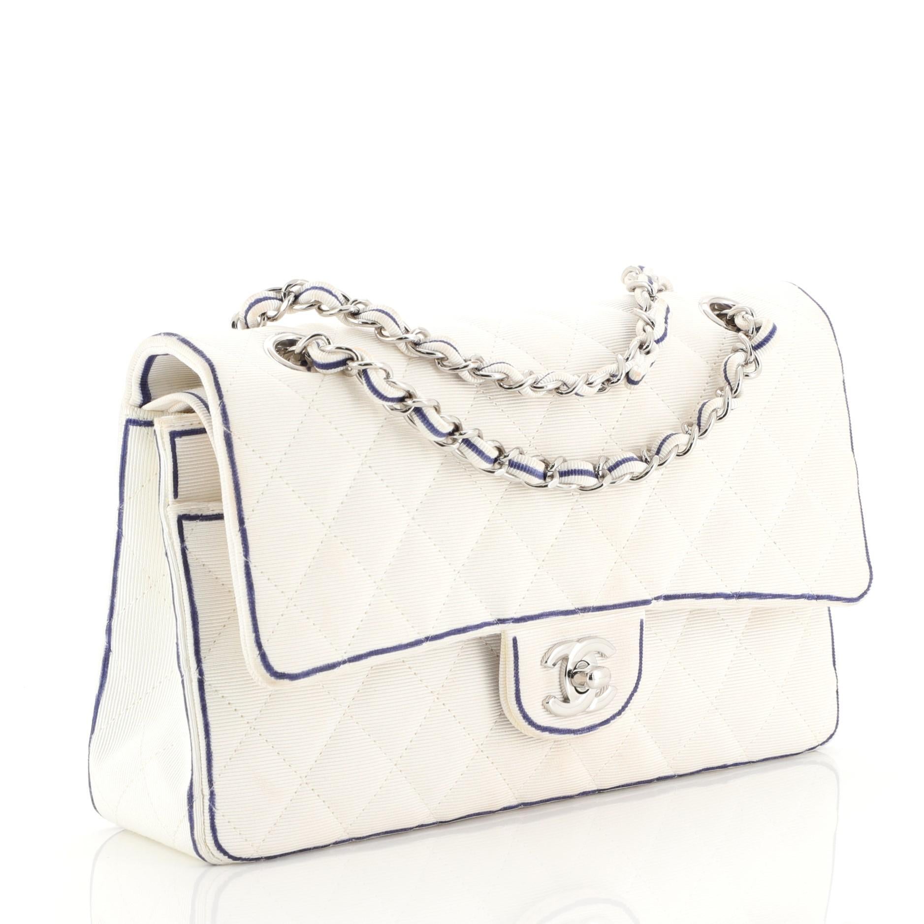 This Chanel Classic Double Flap Bag Quilted Grosgrain Medium, crafted from white quilted grosgrain, features woven-in fabric chain strap, exterior back pocket, and silver-tone hardware. Its CC turn-lock closure opens to a white grosgrain interior