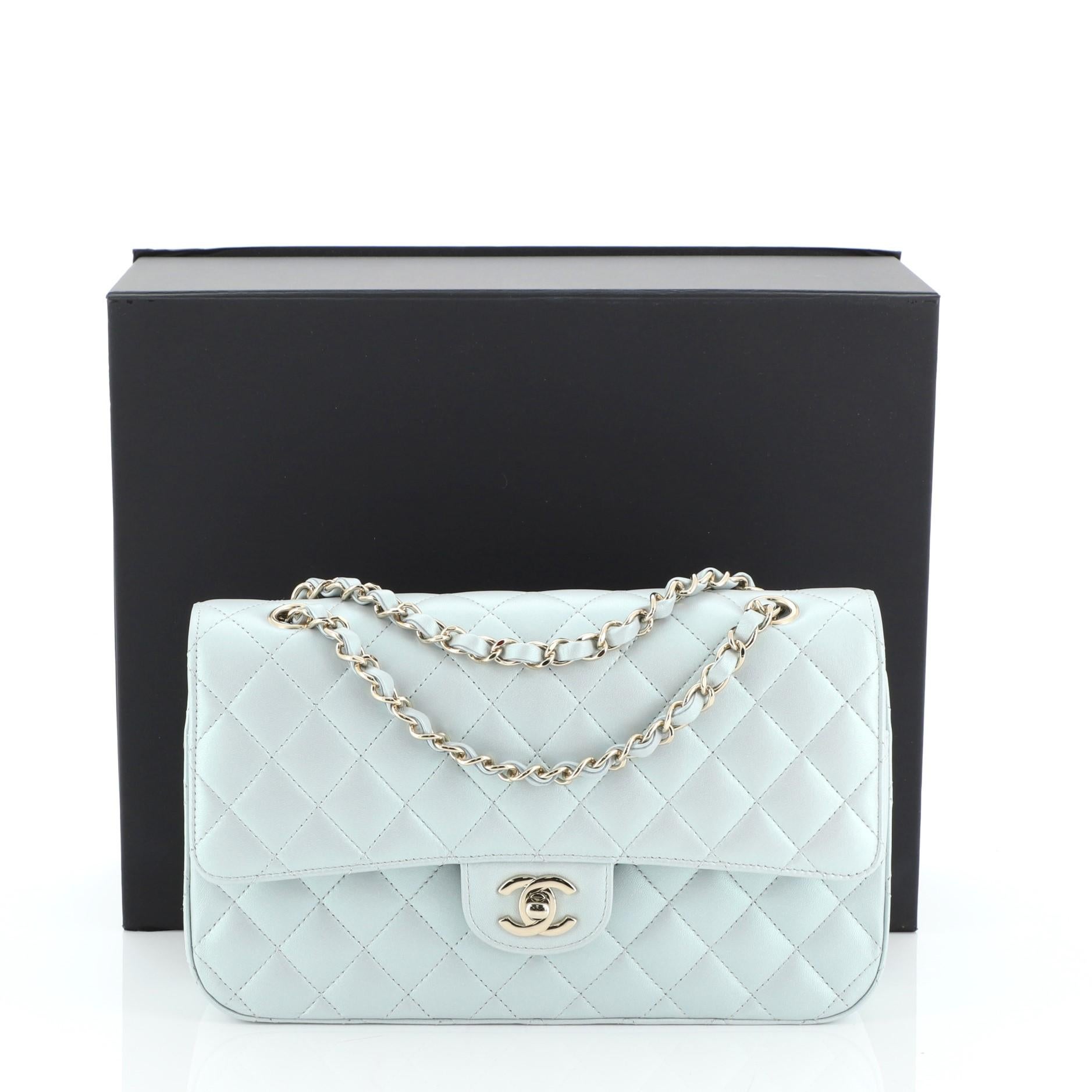 This Chanel Classic Double Flap Bag Quilted Iridescent Calfskin Medium, crafted from blue quilted iridescent calfskin leather, features woven-in leather chain strap, exterior back pocket and gold-tone hardware. Its double flap and frontal CC