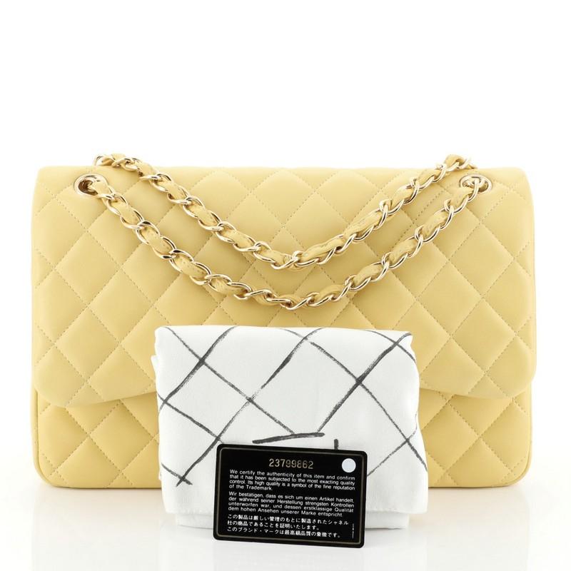 This Chanel Classic Double Flap Bag Quilted Lambskin Jumbo, crafted from yellow quilted lambskin leather, features woven-in leather chain strap, exterior back pocket and gold-tone hardware. Its double flap and frontal CC turn-lock closure opens to a