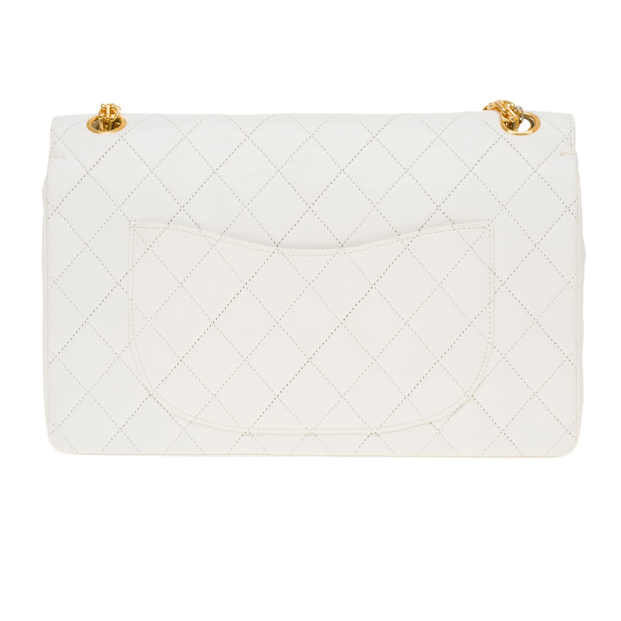 Exceptional Chanel Timeless/Classique handbag with double flap in white quilted lambskin leather, gold metal hardware, a Mademoiselle chain handle in gold metal allowing a hand or shoulder support
Closure with gold metal flap
A patch pocket on the