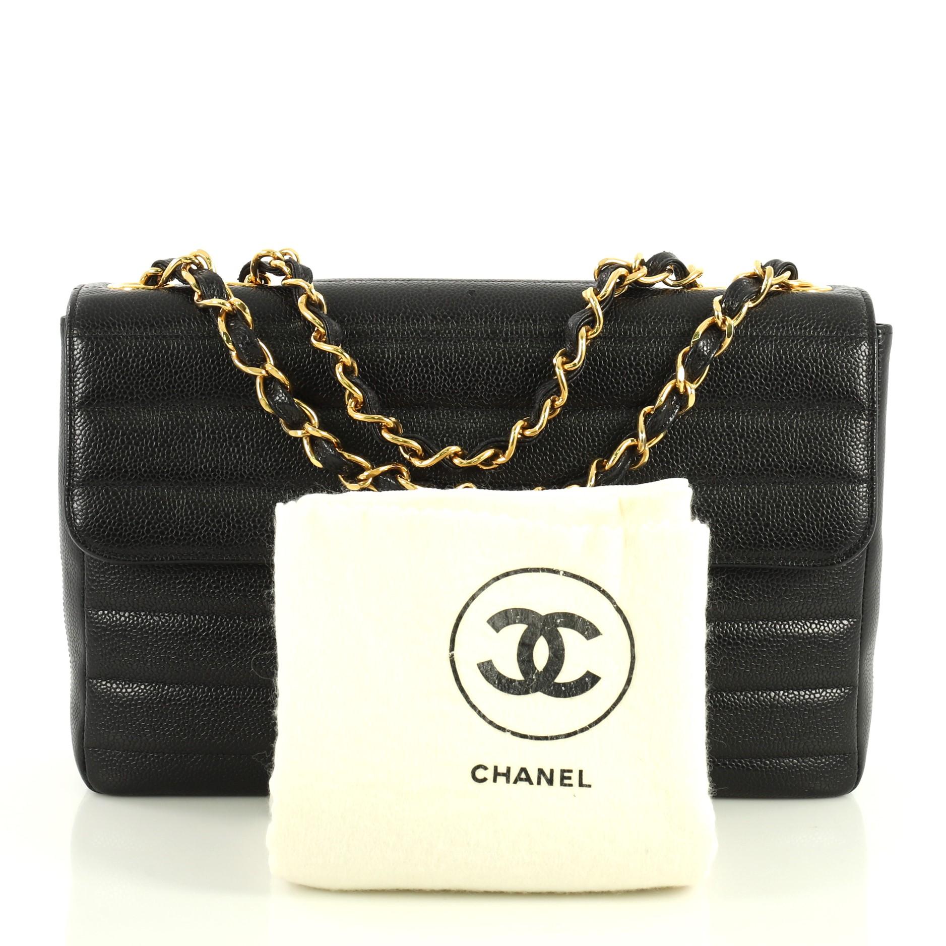 This Chanel Classic Flap Bag Horizontal Quilted Caviar Jumbo, crafted from black horizontal quilted caviar leather, features woven-in leather chain link strap and gold-tone hardware. Its CC turn-lock closure opens to a black leather interior with