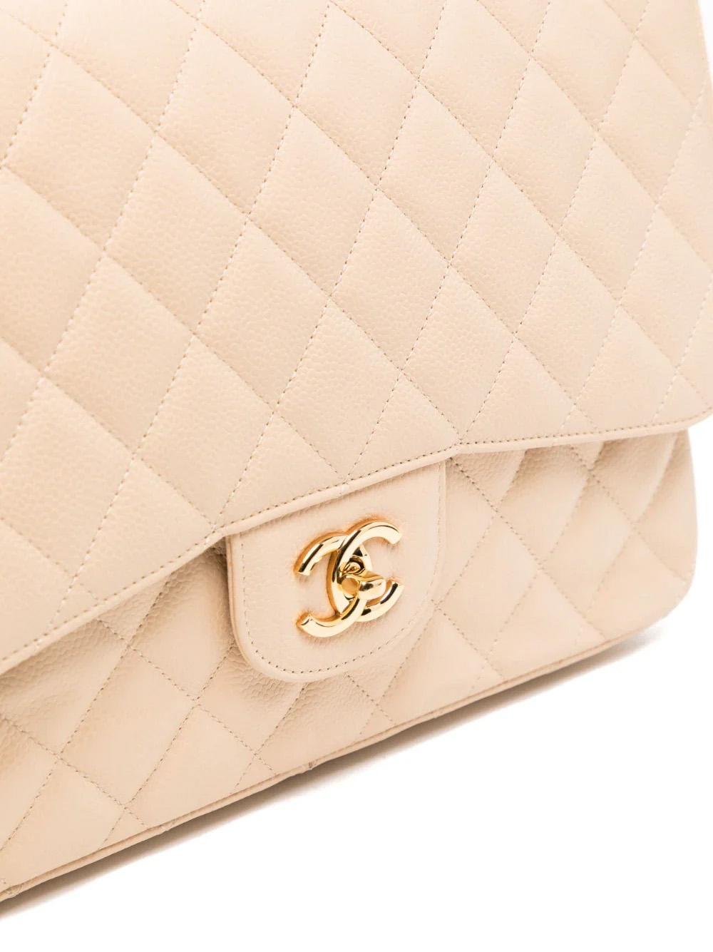 This classic flap jumbo shoulder bag is made from luxurious beige caviar leather with diamond quilting. It features a leather and chain-link shoulder strap, front flap closure with a signature interlocking CC turn-lock fastening, and gold-tone
