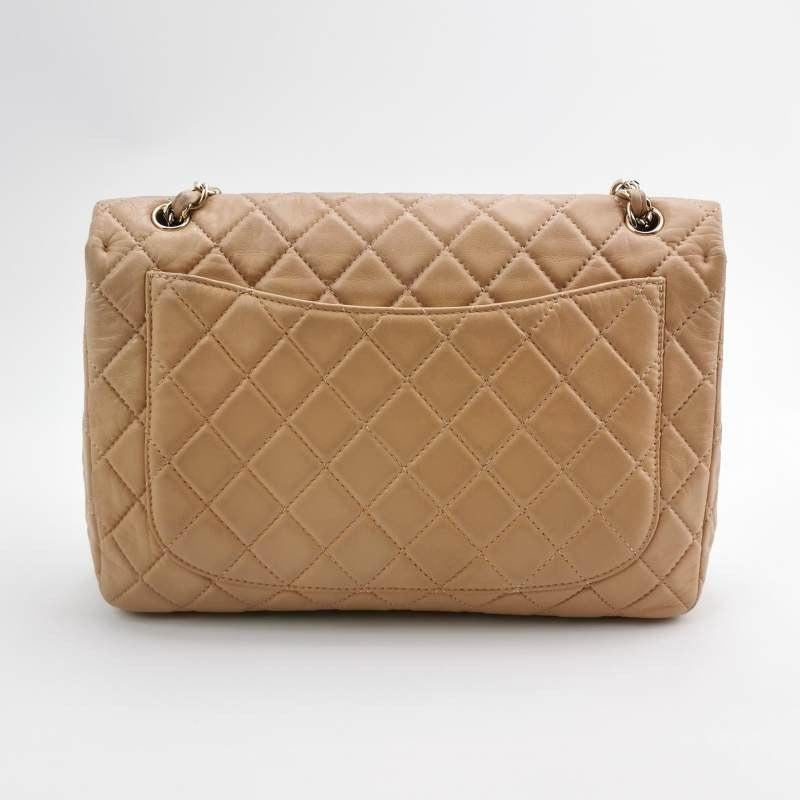 Chanel Classic Flap Maxi Beige Latte Lambskin Leather Giant Gold-tone CC Logo
 These are professional photos of the actual bag.
 Experience timeless elegance with the Chanel Classic Flap Maxi Shoulder Bag. Crafted with luxurious lambskin leather and