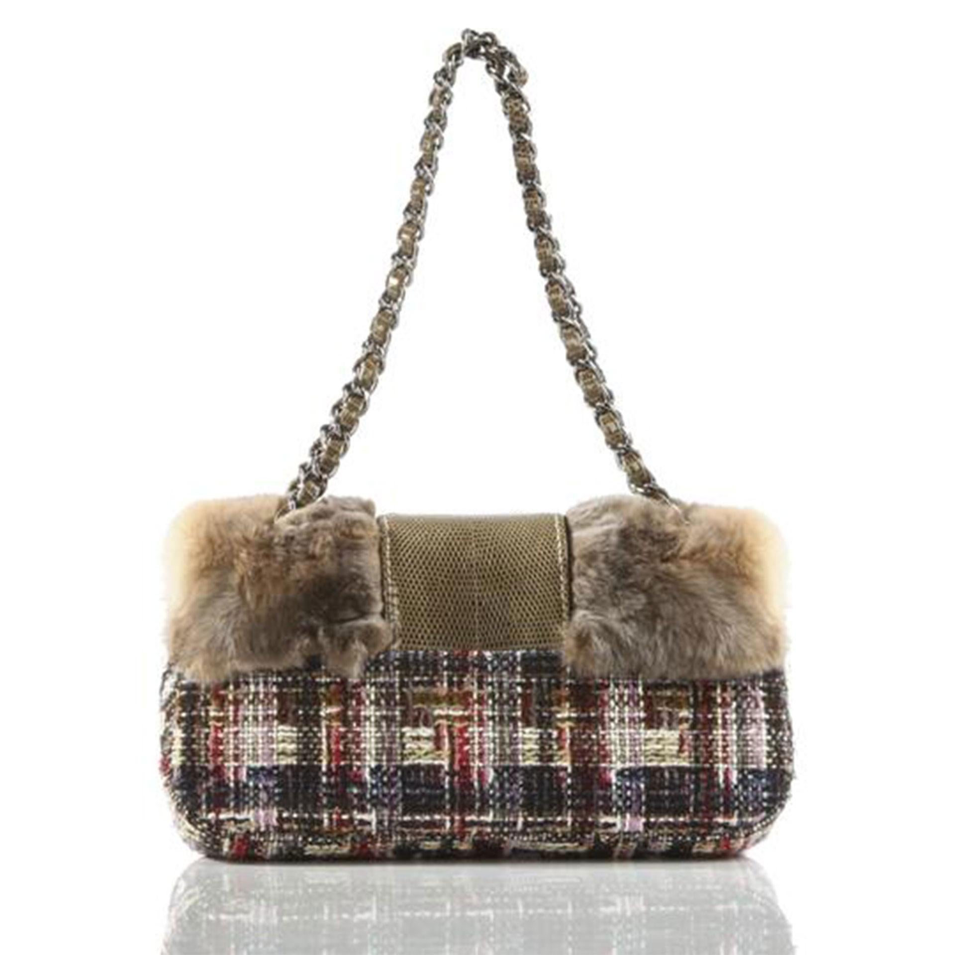 Chanel faux fur multi color tweed and lizard printed flap with CC logo clasp

2005 {VINTAGE 17 Years}
Silver hardware
Interior flap lambskin lining
Soft graffiti interior lining
Classic center zippered pocket
Lizard printed leather interwoven