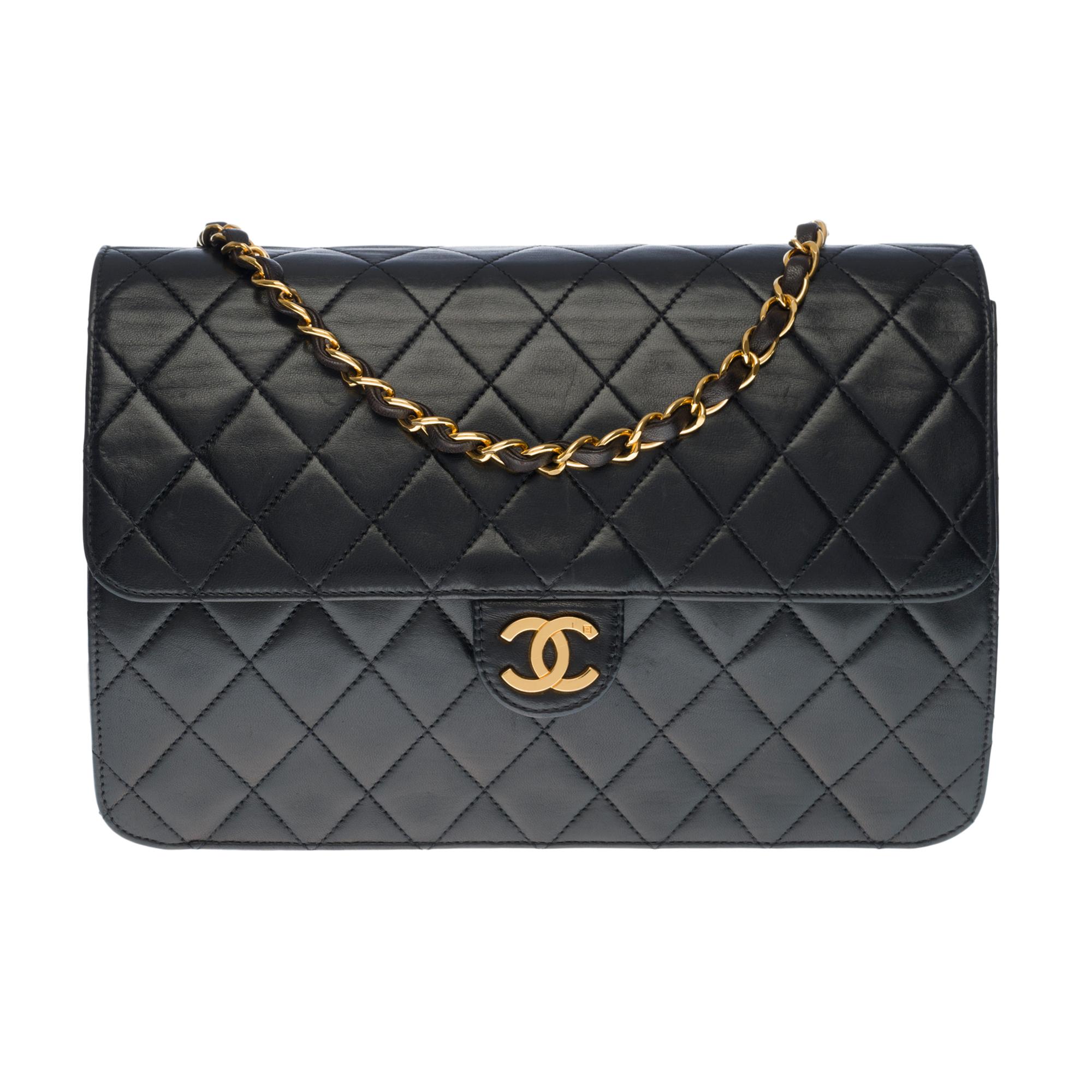 Stunning Chanel Classique shoulder Flap bag in black quilted leather, gold metal hardware, a gold metal chain handle interwoven with black leather allowing a shoulder support
Gilded metal logo closure on flap, snap closure
Lining in burgundy