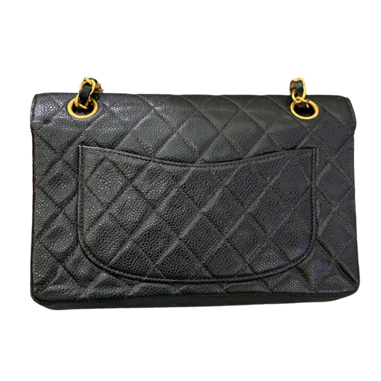 This one-of-a-kind Chanel Classic Flap Vintage bag exudes sophistication and timeless elegance. Crafted from black caviar leather, it is adorned with 24k gold hardware. Made in between 2000-2002, this bag dates more than 20 years, remaining in
