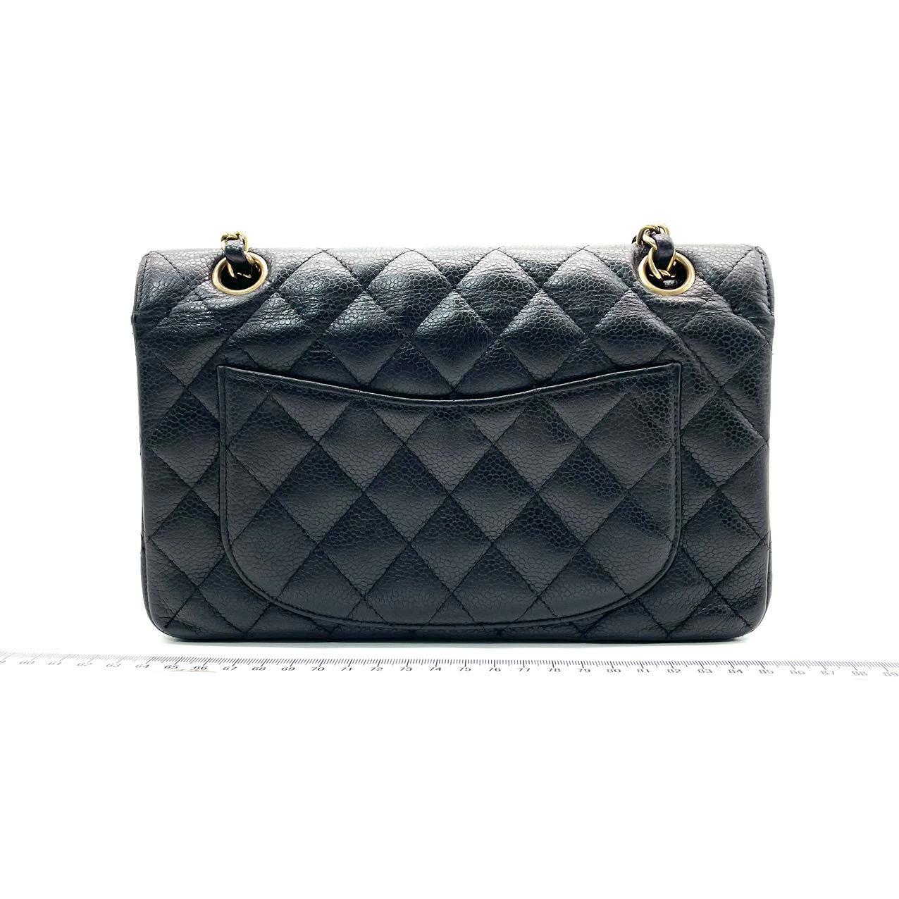 This one-of-a-kind Chanel Classic Flap Vintage bag exudes sophistication and timeless elegance. Crafted from black caviar leather, it is adorned with 24k gold hardware. Made in between 2004-2005, this bag dates almost 20 years, remaining in