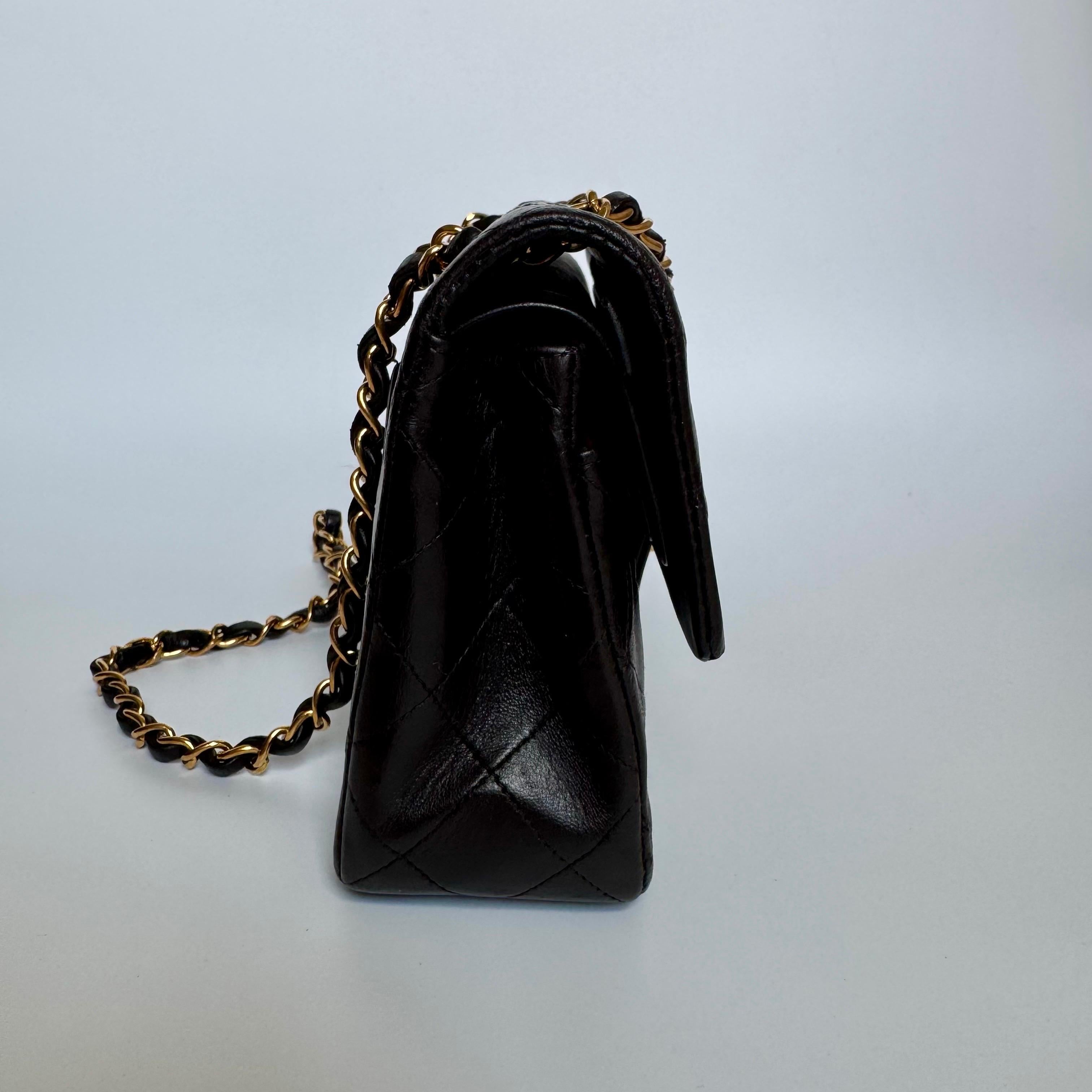 This one-of-a-kind Chanel Classic Flap Vintage bag exudes sophistication and timeless elegance. Crafted from lambskin leather in rare dark chocolate brown color, it is adorned with 24k gold hardware. Made in between 1994-1996, this bag dates almost