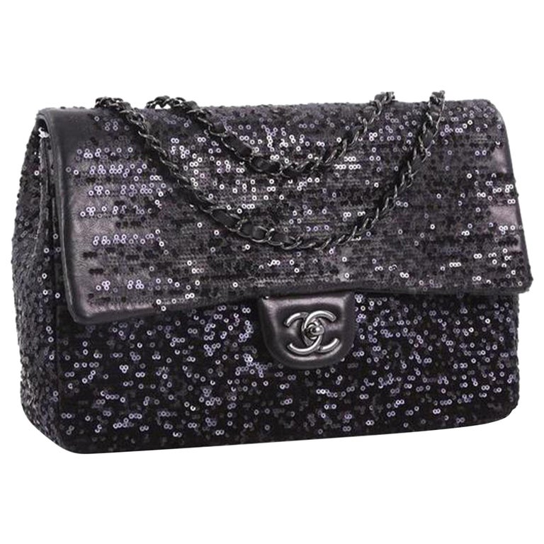 This Chanel Classic Single Flap Bag Sequins Jumbo, crafted in black sequins, features woven in leather chain link strap, exterior back slip pocket, and gunmetal-tone hardware. Its CC turn-lock closure opens to a black fabric interior with zip