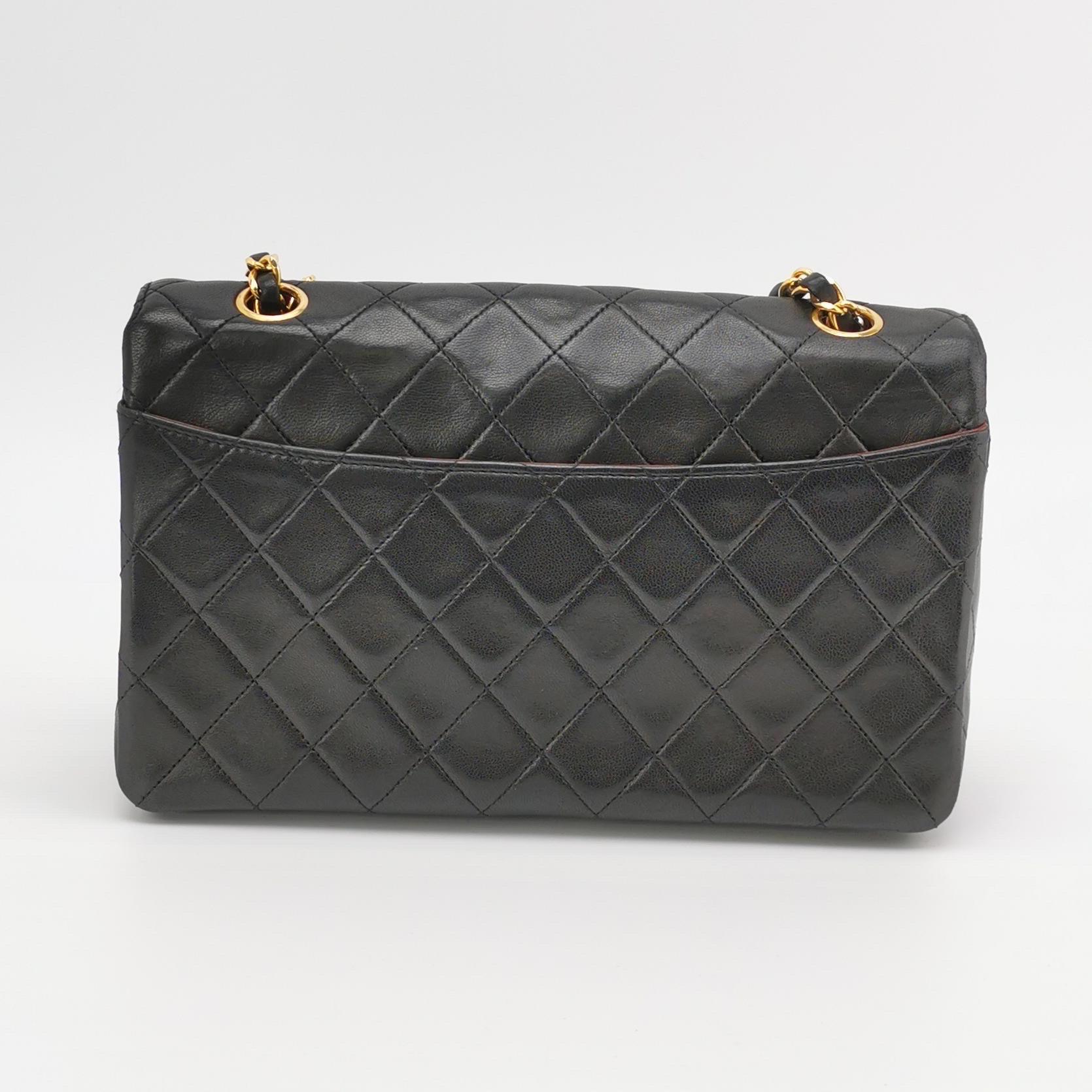 Diese einmalige Chanel Classic Flap Vintage Tasche strahlt Raffinesse und zeitlose Eleganz aus. Sie ist aus luxuriösem Lammleder gefertigt und mit 24-karätigen Goldbeschlägen verziert. Diese Tasche wurde zwischen 1989 und 1991 hergestellt und ist