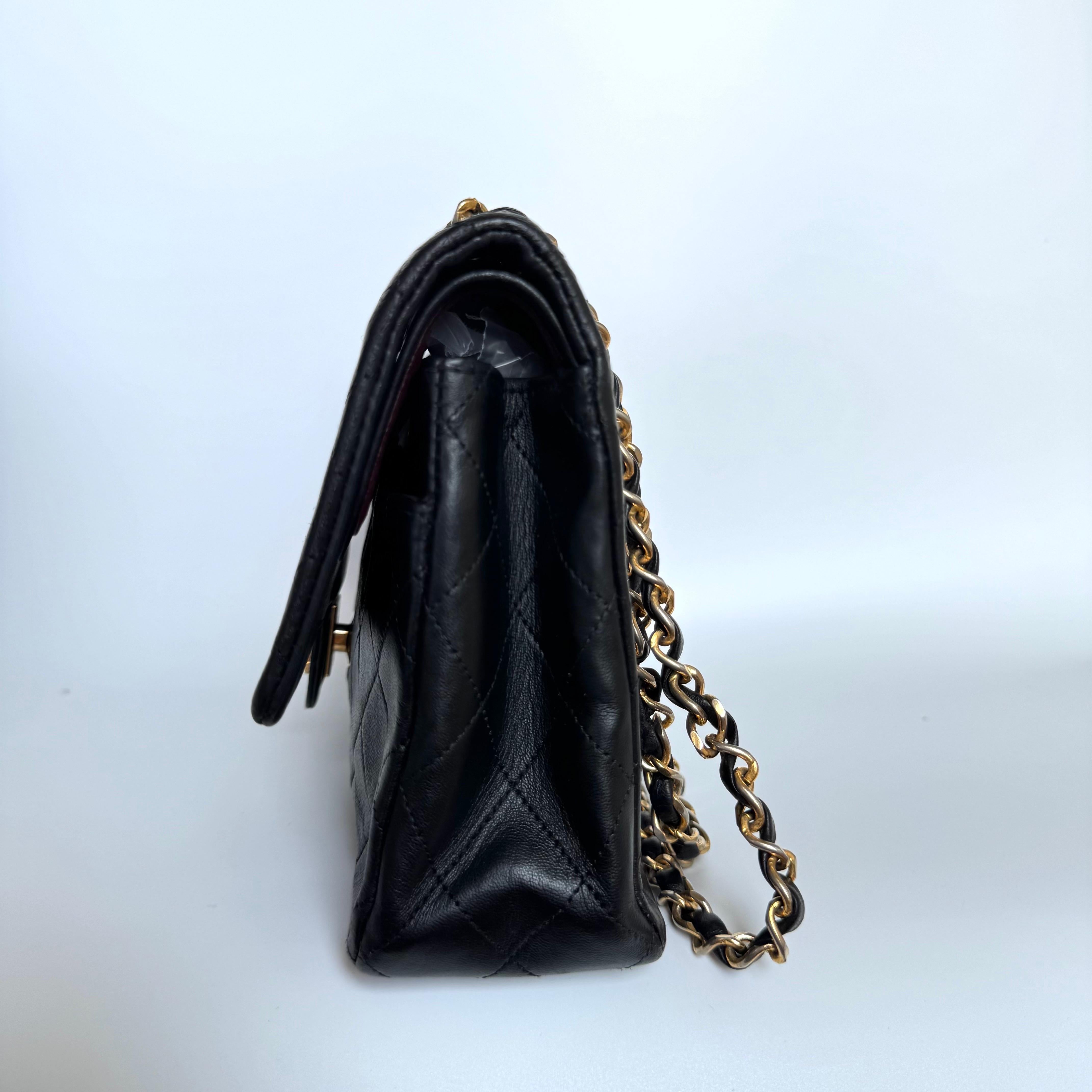 Diese einmalige Chanel Classic Flap Vintage Tasche strahlt Raffinesse und zeitlose Eleganz aus. Sie ist aus luxuriösem schwarzem Lammleder gefertigt und mit 24-karätigen Goldbeschlägen verziert. Diese Tasche ist wirklich ein Stück Luxus, das es wert