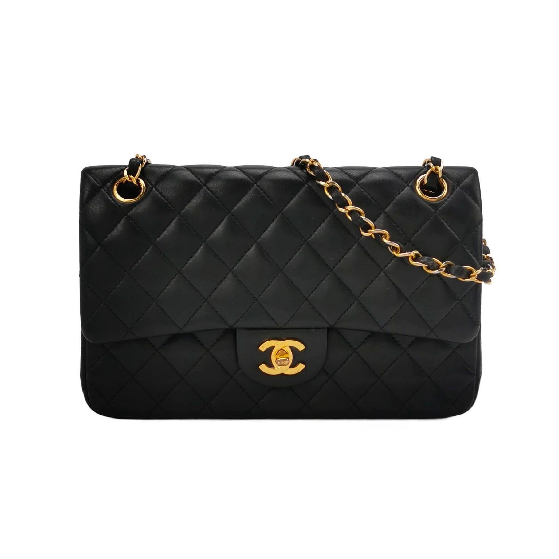 Diese einmalige Chanel Timeless Classic Flap Vintage Tasche strahlt Raffinesse und zeitlose Eleganz aus. Sie ist aus luxuriösem schwarzem Lammleder gefertigt und mit 24-karätigen Goldbeschlägen verziert. 

ZUSTAND: AUSGEZEICHNETER ZUSTAND

Diese