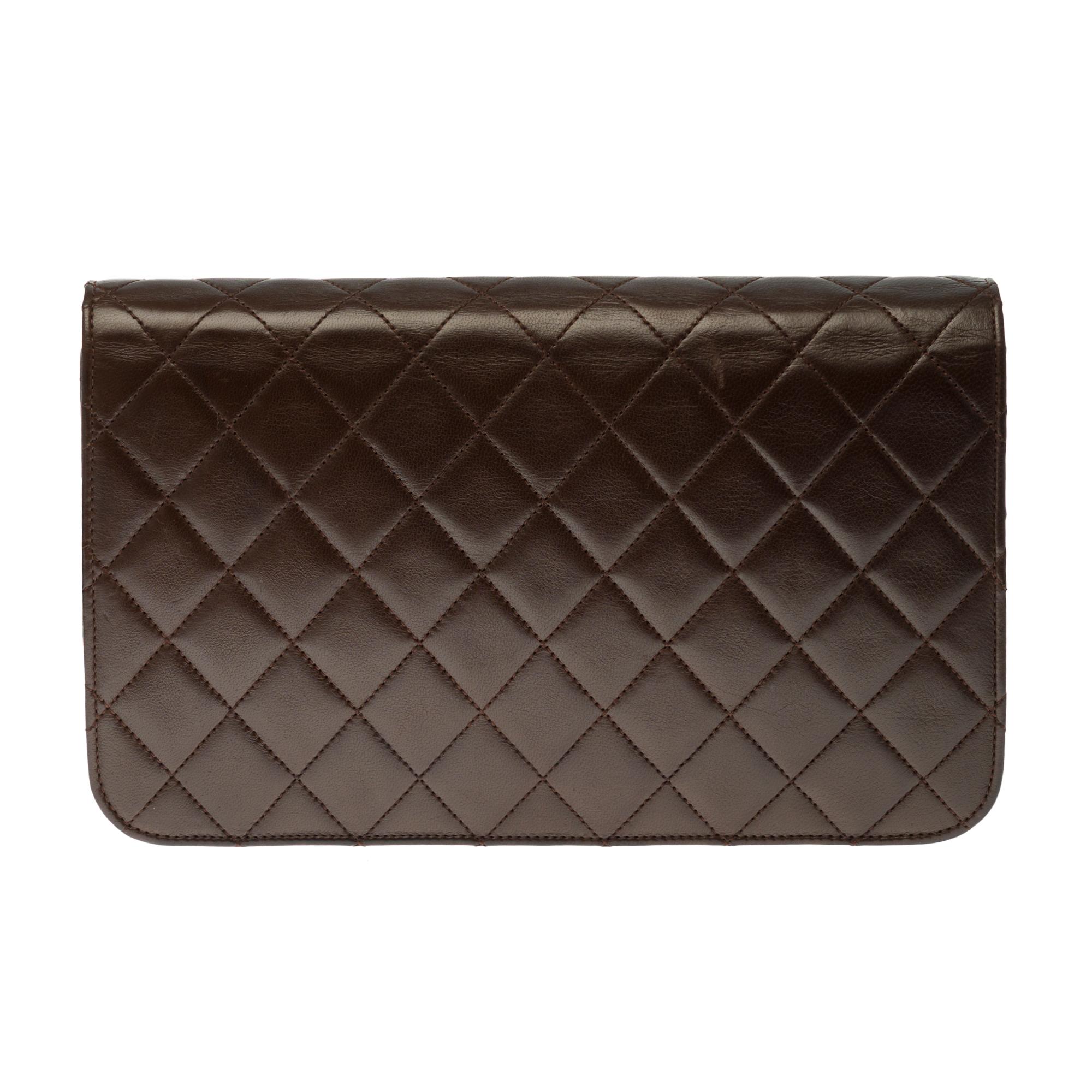 Chic Chanel Classique shoulder bag 25 cm in black quilted lambskin leather, gold-tone metal hardware, a gold-tone metal chain handle intertwined with black leather for a shoulder support .

Gilded metal logo closure on flap.
Lining in burgundy