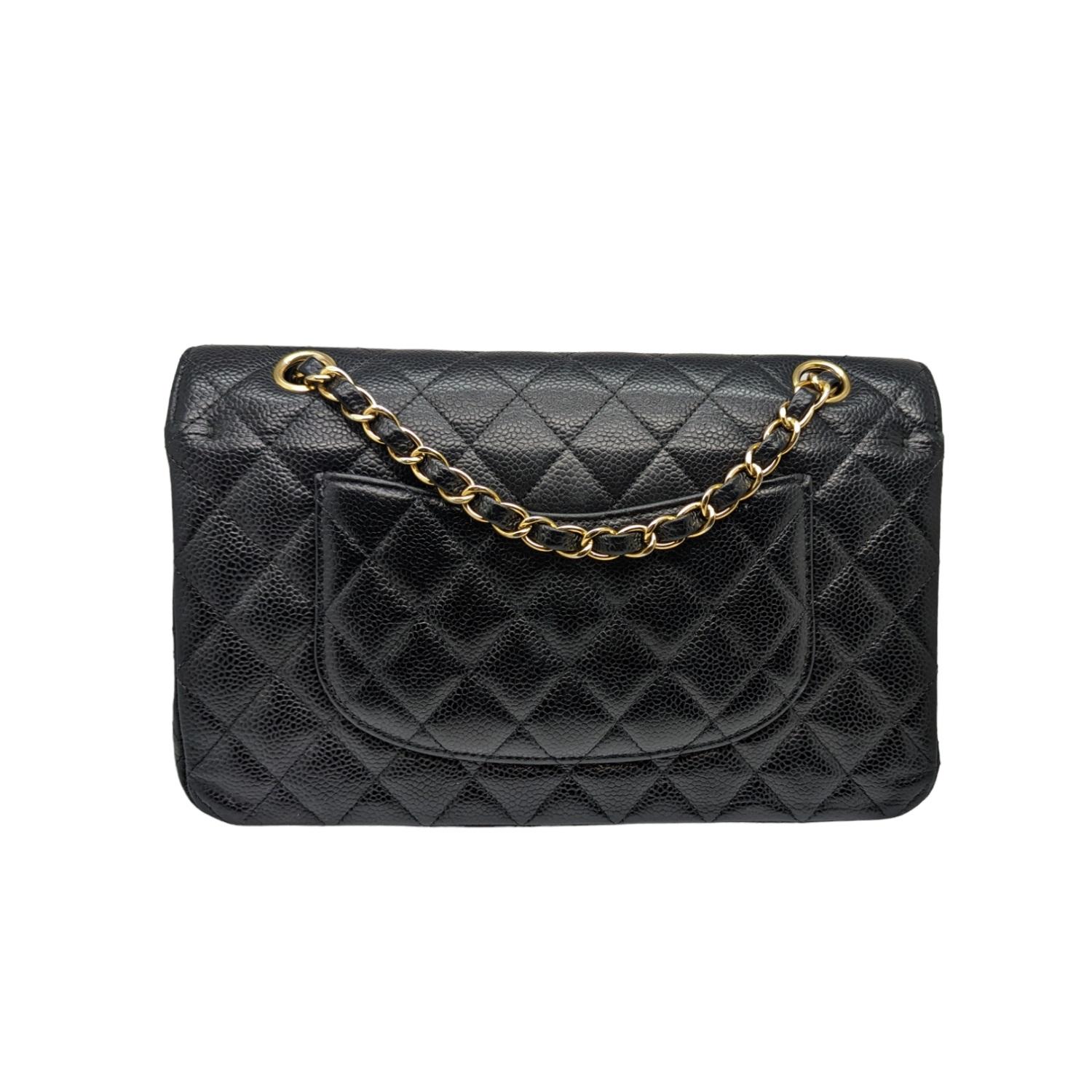 This elegant shoulder bag is crafted of luxurious caviar textured leather in black. The bag features a leather threaded gold chain-link shoulder strap, a rear patch pocket, and a crossover flap with a gold classic CC turn lock. The flap opens to