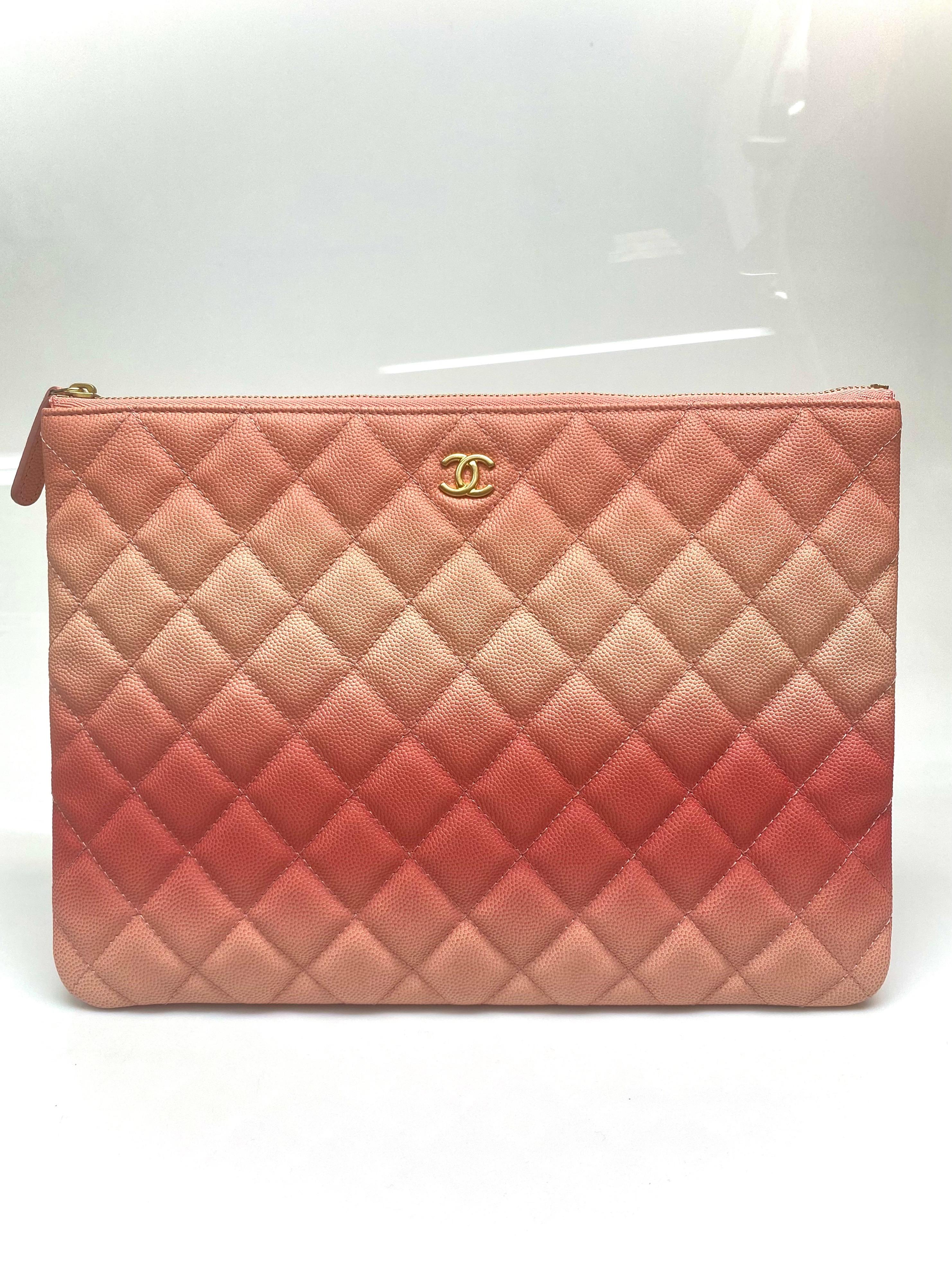 This Chanel quilted clutch in a coral ombre is an absolutely stunning piece. The bag features a top zipper closer, gold CC logo, one interior compartment and one medium sized open flap at the back. Bag itself is in great condition apart from a few