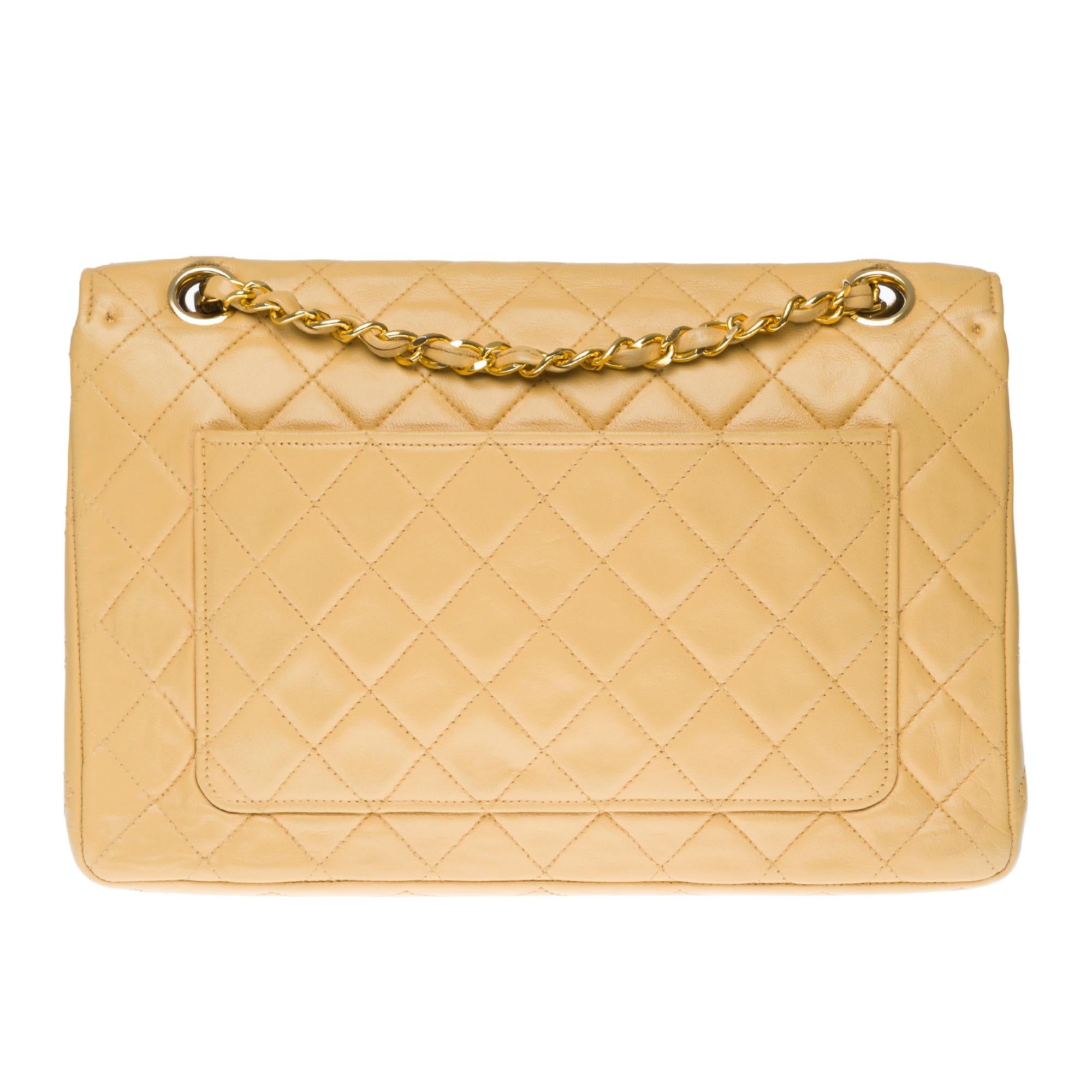Lovely Chanel Classique 25cm bag with flap in beige quilted lambskin leather, edging in coral leather on flap, gold metal hardware, golden metal chain interwoven with beige leather.
Flap closure, gold-tone CC symbol.
Lining in beige leather, 1
