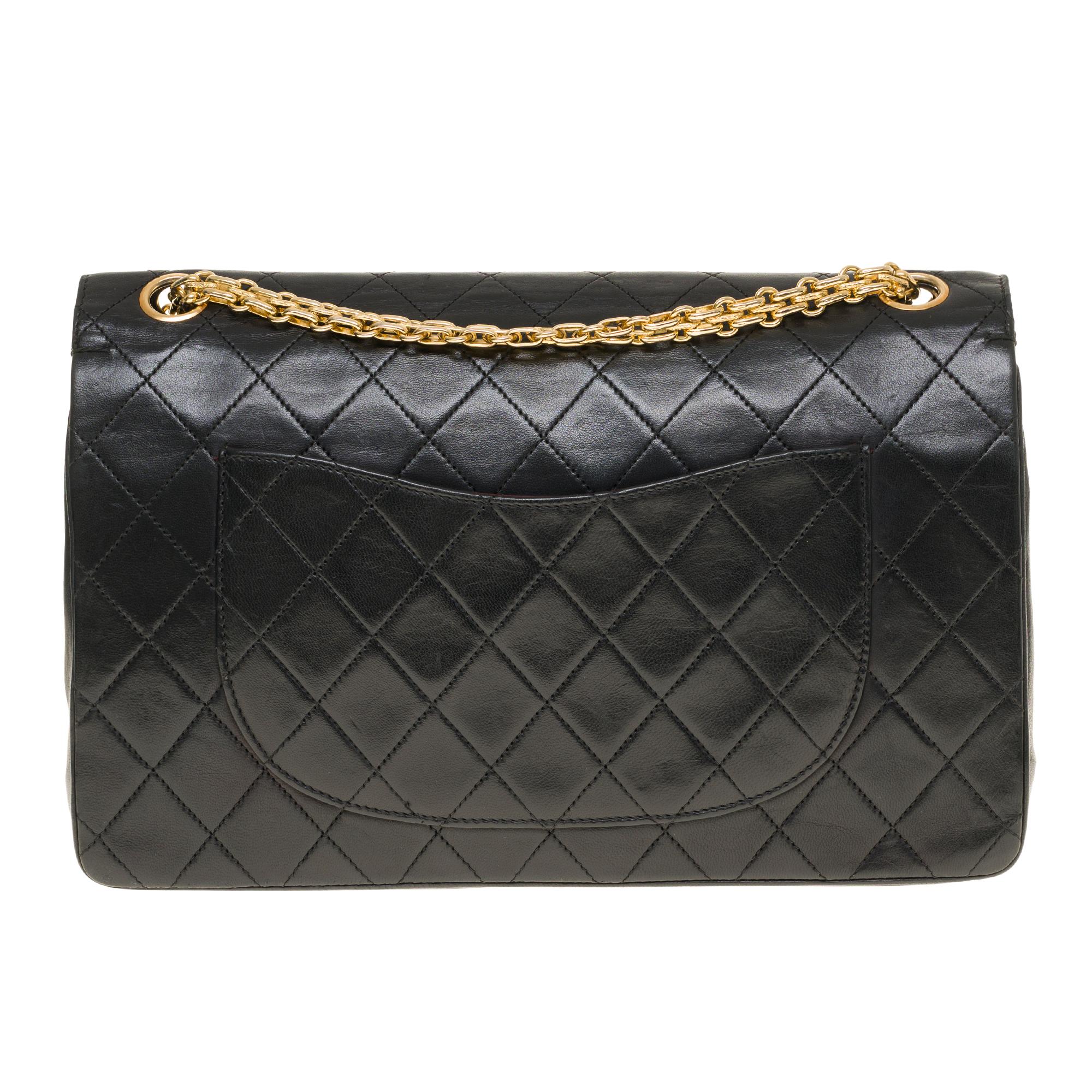 Beautiful Chanel Timeless/Classique 27cm handbag with double flap in black quilted lambskin leather, gold metal hardware, a Mademoiselle chain handle in gold metal allowing a hand or shoulder support.

Closure with gold metal flap.
A patch pocket on