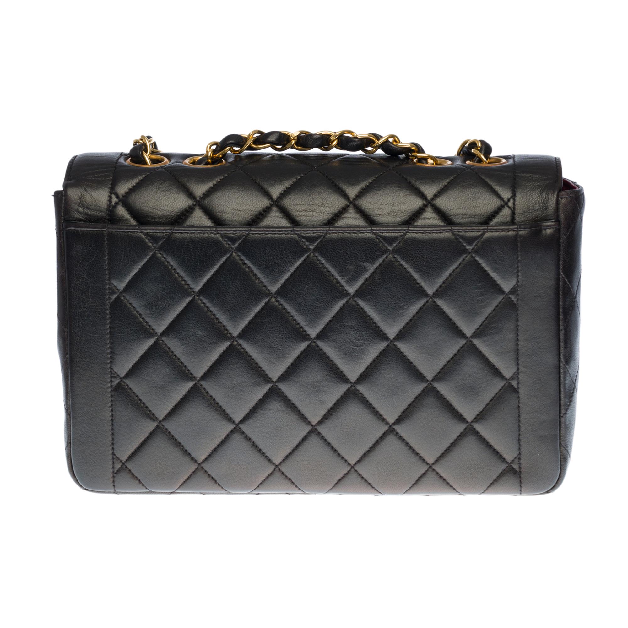 Beautiful Chanel Classic shoulder flap bag in black quilted lambskin, gold-plated metal hardware, a gold-plated metal chain handle interlaced with black leather for hand or shoulder support

Gold Metal Flap Closure
A patch pocket on the back of the