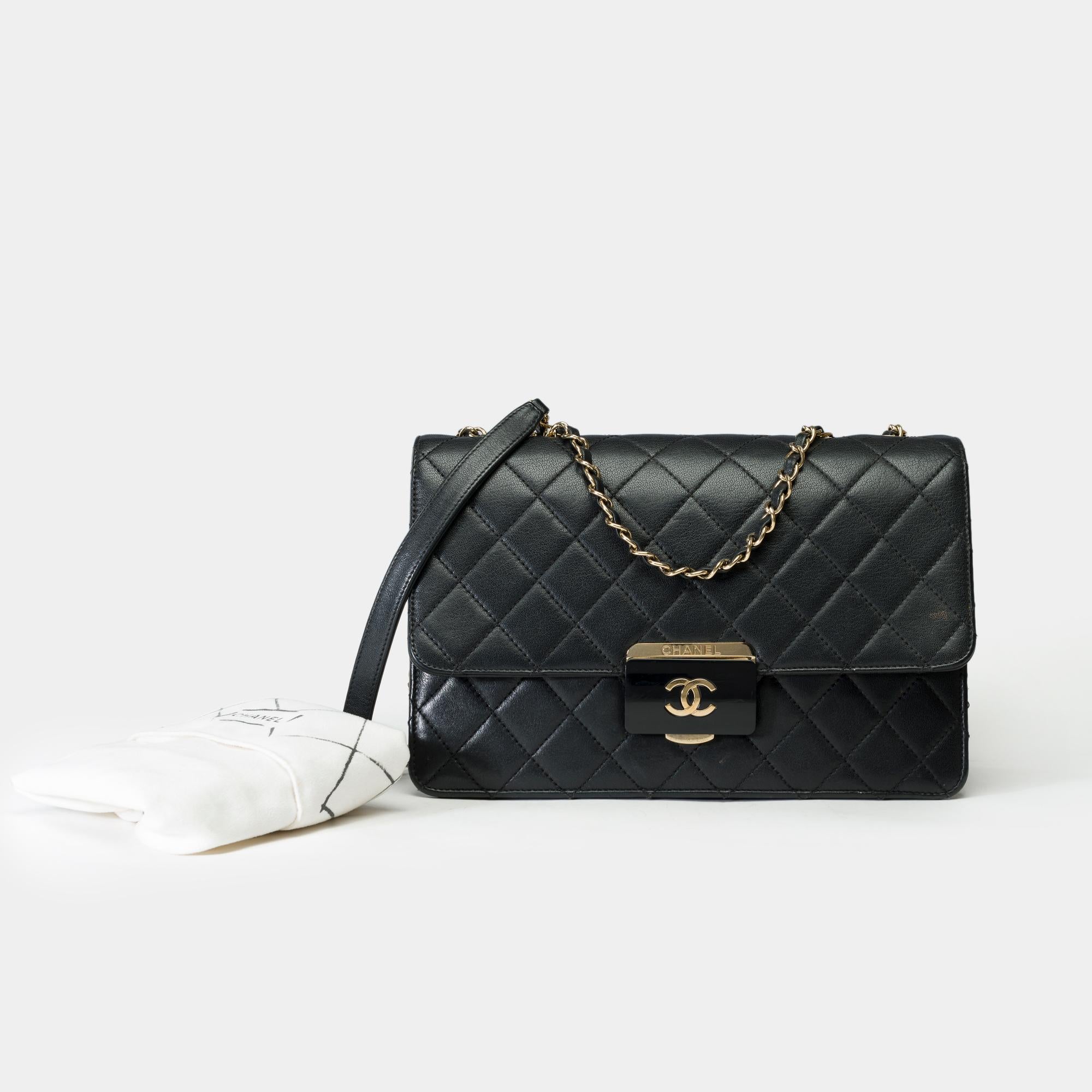 Raro bolso Chanel Classic de una sola solapa en piel acolchada negra con adornos de metal dorado, cadena entrelazada de metal dorado y piel negra que permite llevarlo al hombro o cruzado

Solapa única
Cierre con logotipo de metal dorado en la