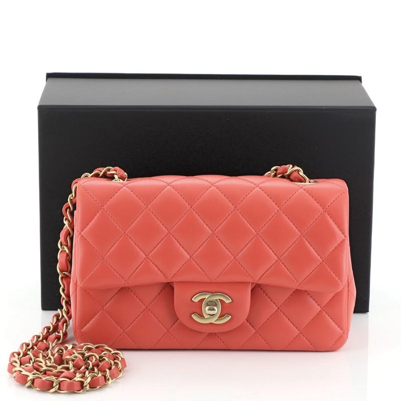 This Chanel Classic Single Flap Bag Quilted Lambskin Mini, crafted in pink quilted lambskin leather, features woven-in leather chain link strap, exterior back slip pocket, and matte gold-tone hardware. Its CC turn-lock closure opens to a pink