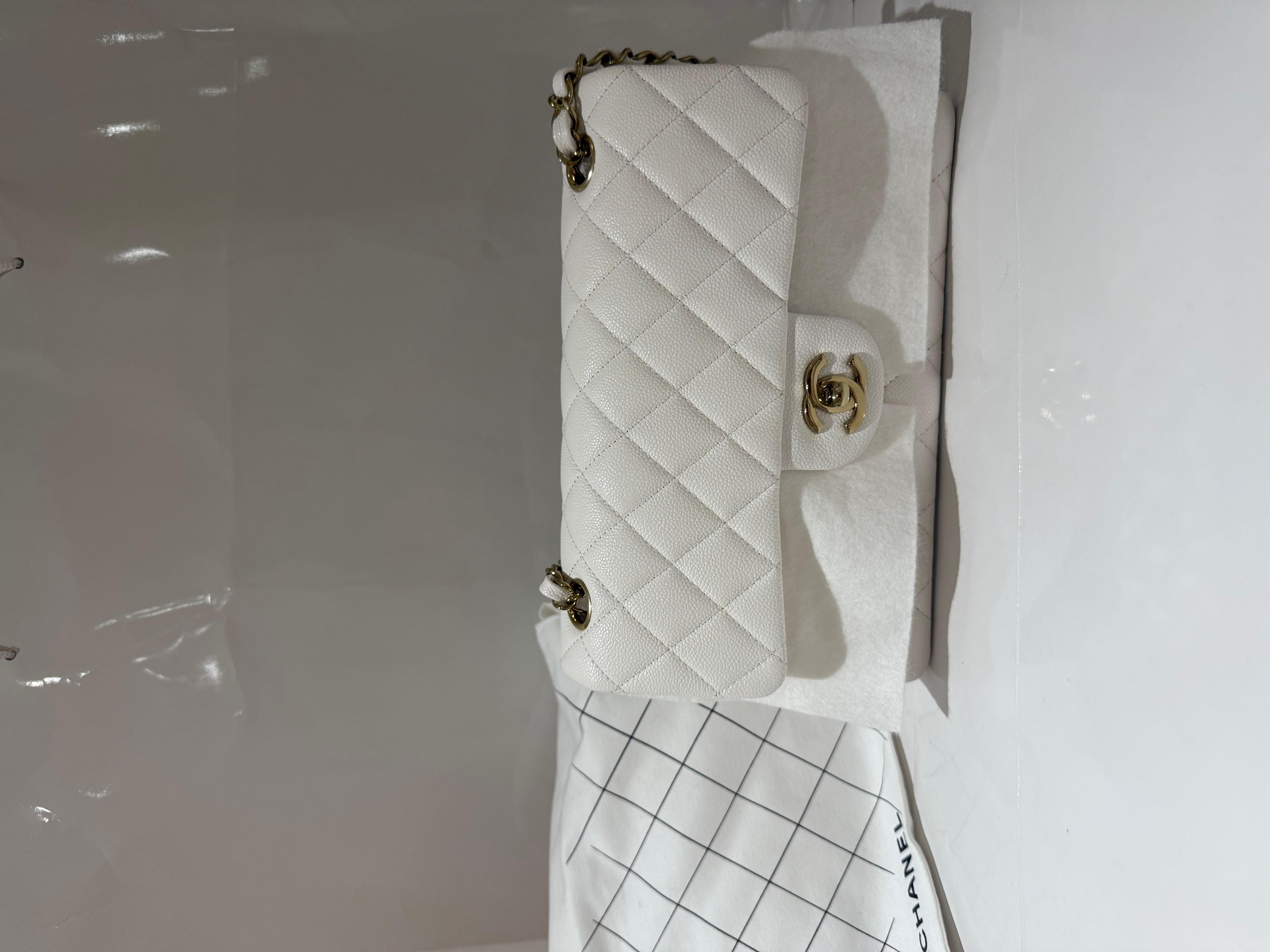 Petit sac classique à double rabat de Chanel en caviar blanc LGHW.
Ce sac à bandoulière Chanel est réalisé en cuir de caviar blanc, offrant un design sophistiqué et intemporel. Il mesure 23 cm de large,  D'une hauteur de 14,5 cm et d'une profondeur