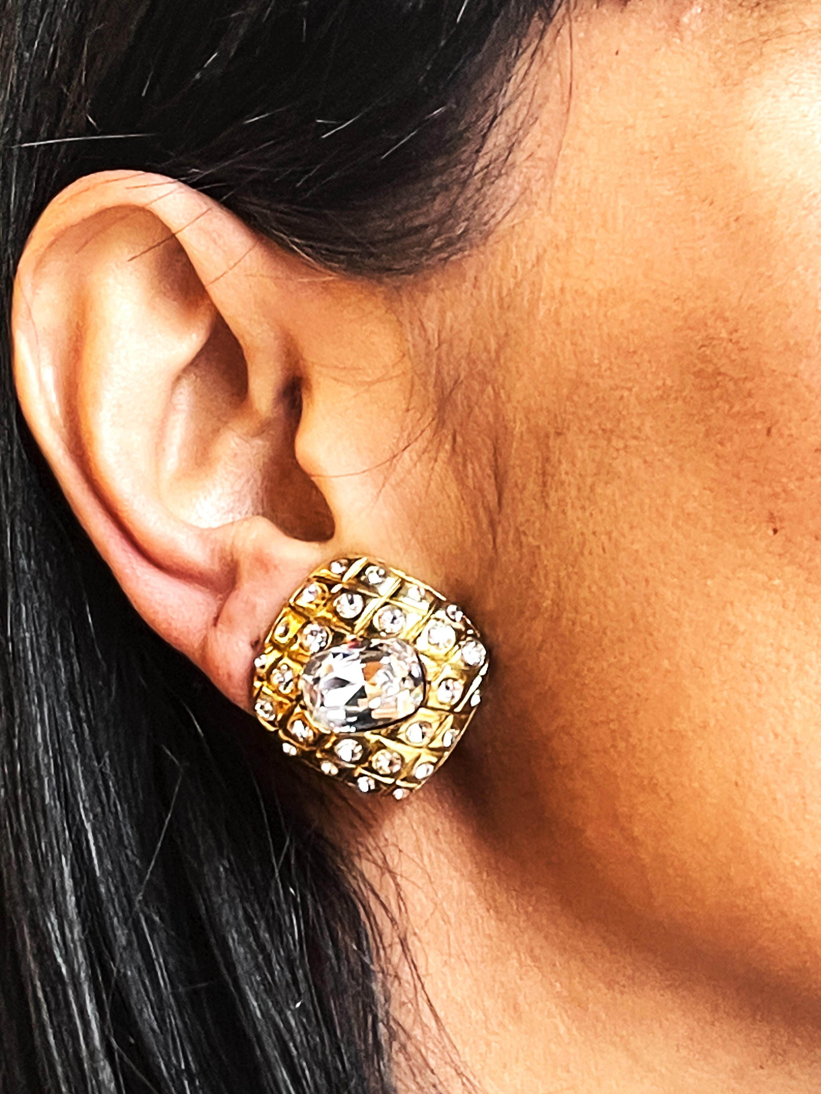CIRCA
 
Iconici orecchini a clip di Chanel (Made in France) della 1a collezione di Victoire de Castellane, trapuntati con piccoli strass nel mezzo. Al centro c'è un grande strass Swarovski a taglio rettangolare. Placcato in oro. 
Victoire de