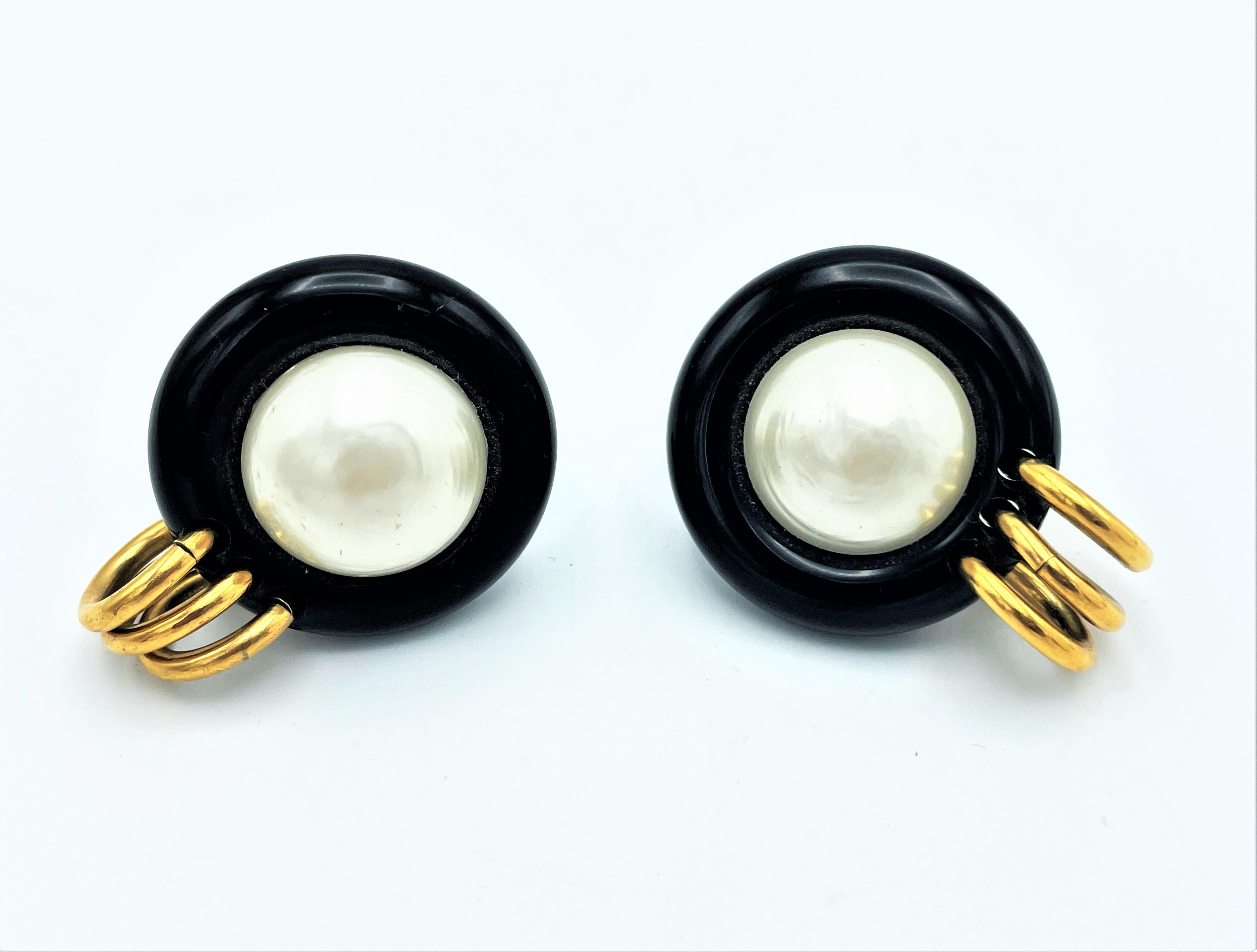 About
Large round black plastic ear clip threaded with a large handmade pearl and three gold rings. Designed by Victoire Castellane for Chanel in the 1990s
Measurement
Diameter 1,5 inches ( 4 cm)
Pearl size 1 inches   ( 2,3 cm)
Deep  0,71 inches 