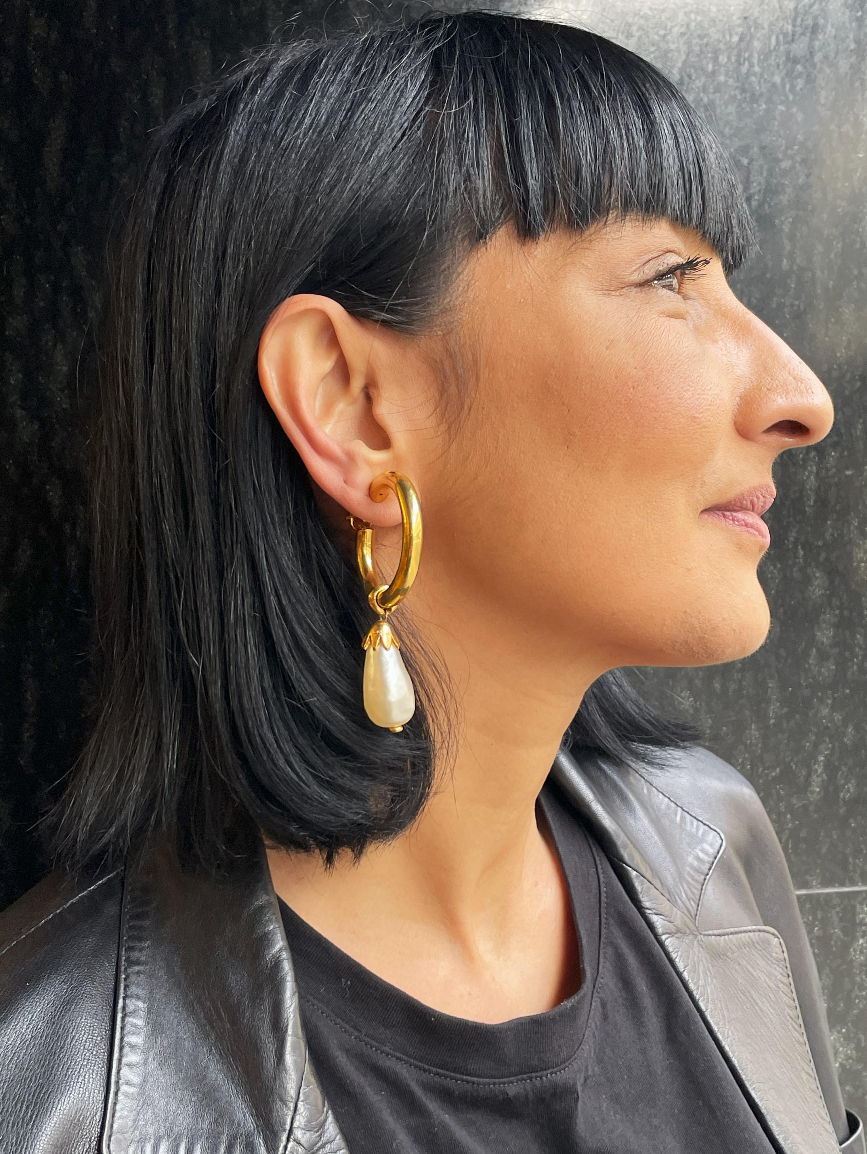 Orecchini a cerchio in minerale creolo con perle rimovibili di Chanel (Made in France), placcati in oro 24 carati. 
Gli orecchini erano di Susan Gutfreund di NY, una buona amica di K.L. Una bellissima perla incastonata lunga 3,3 cm, appesa con un