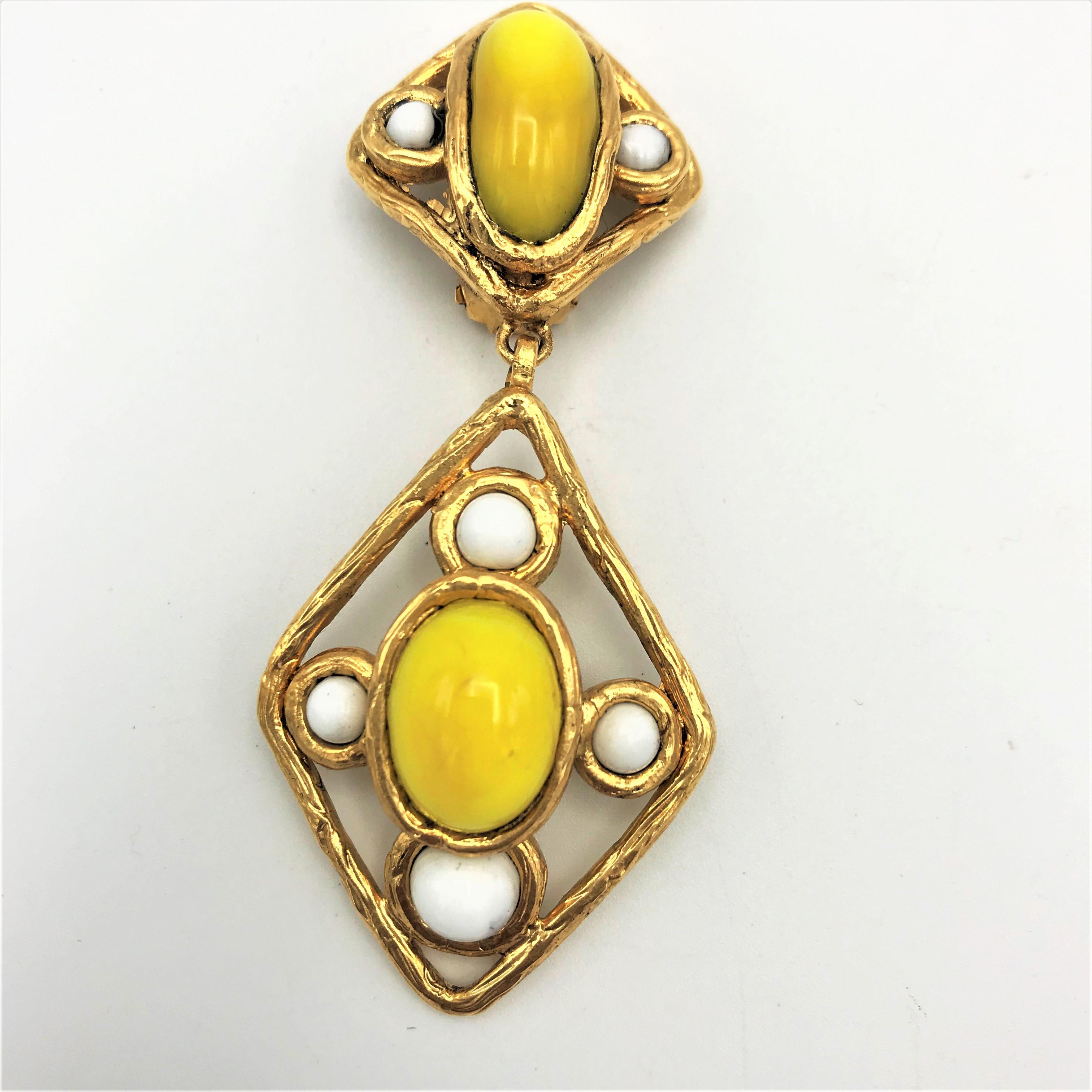 Chanel Ohrclip (Made in France), 2 teilig mit trachenförmigem Anhänger mit gelber und weißer Glaspaste, vergoldet, um 2000, sehr guter Zustand.

Maße: 
Länge 7, 5 cm, obere Teil 2,6 x 2,6 cm, untere beweglicher  Drachen 4,4 x 3 cm 
Breite  3   