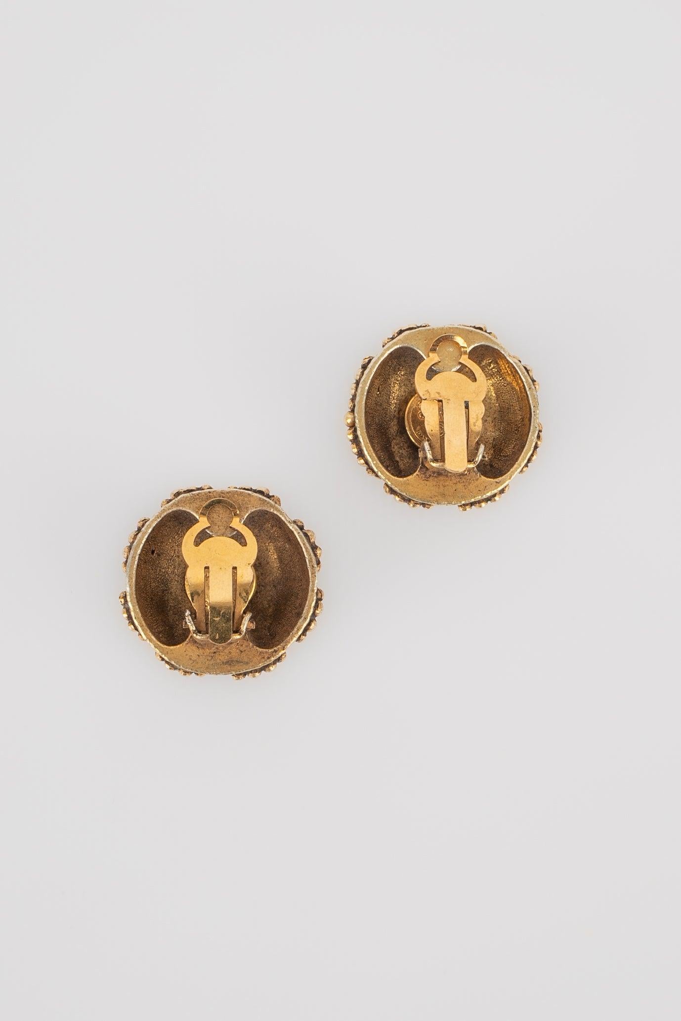 Chanel - (Made in France) Orecchini a clip in metallo dorato con cabochon di perle e pasta di vetro.

Informazioni aggiuntive:
Condizioni: Ottime condizioni
Dimensioni: Diametro: 2,5 cm

Riferimento del venditore: BOB6
