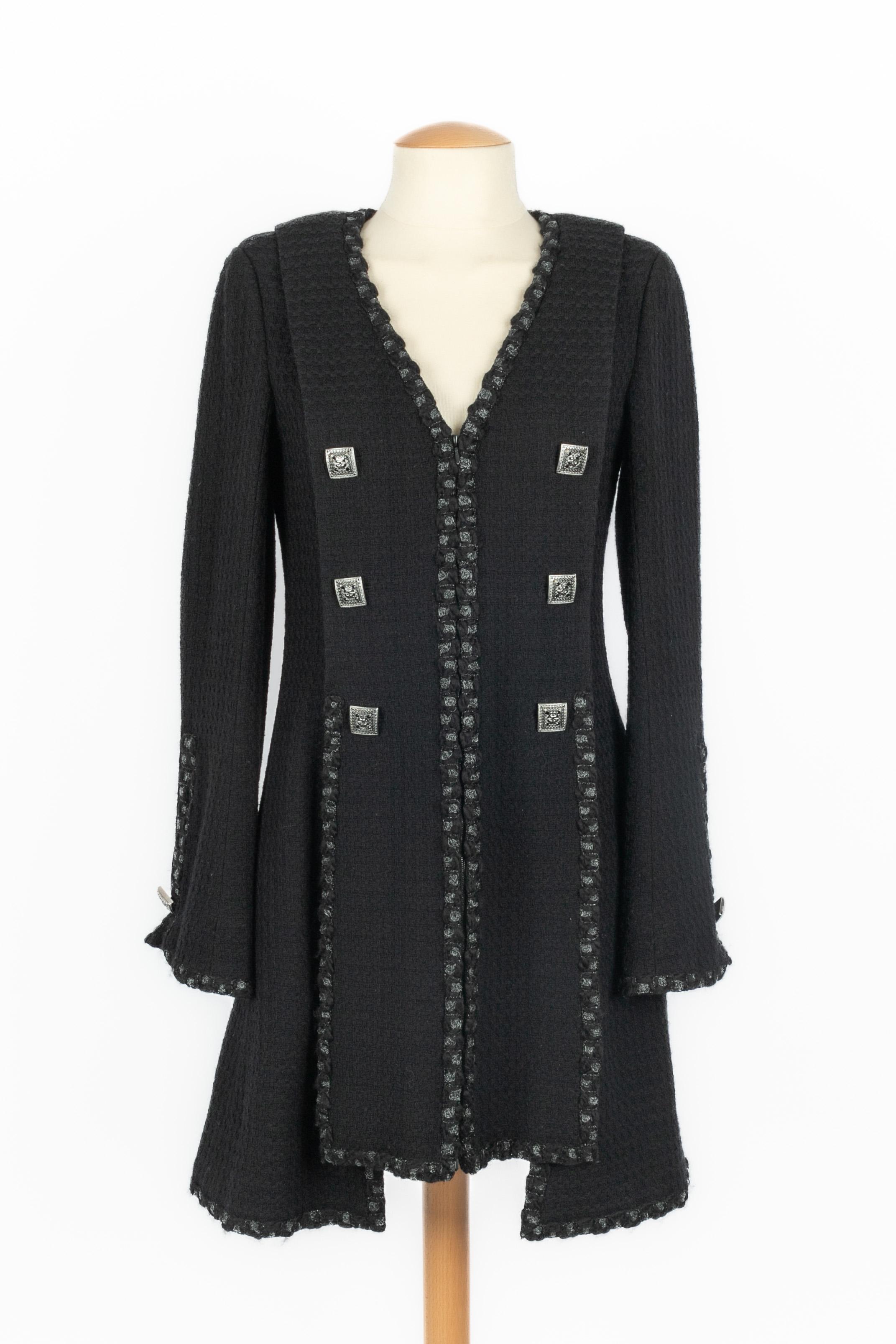 CHANEL - (Fabricado en Francia) Abrigo negro de lana de largo medio ribeteado con trenzas plateadas y negras. Botones de joyería. Talla 38FR. Colección Pre-Fall PAris-Byzance 2011, bajo la dirección artística de Karl Lagerfeld.

Estado:
Muy buen