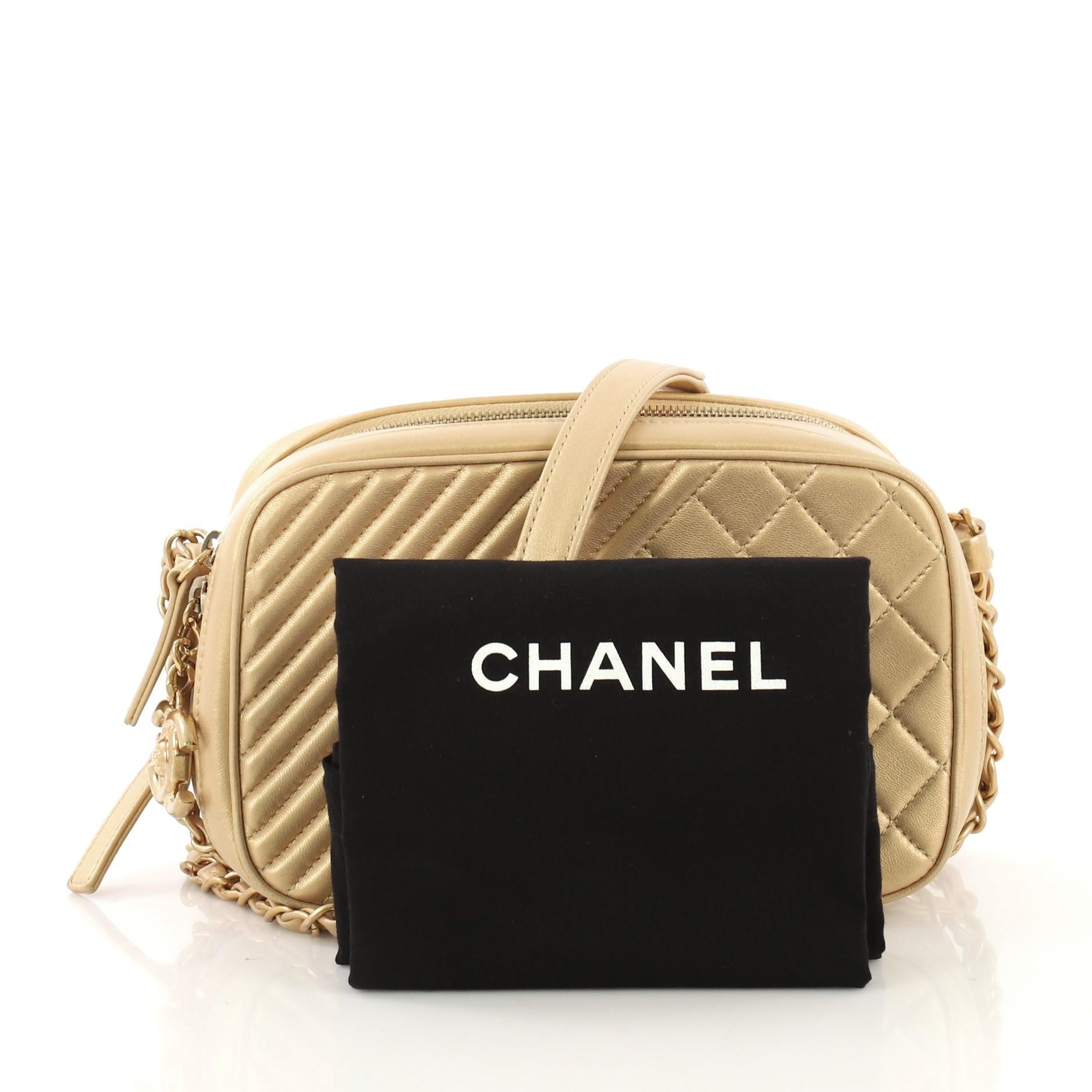 This Chanel Coco Boy Camera Bag Quilted Leather Small, crafted from gold quilted leather, features woven-in leather chain link strap with leather pad, two zip compartments, oversized CC charm, and matte gold-tone hardware. Its two-way zip closure