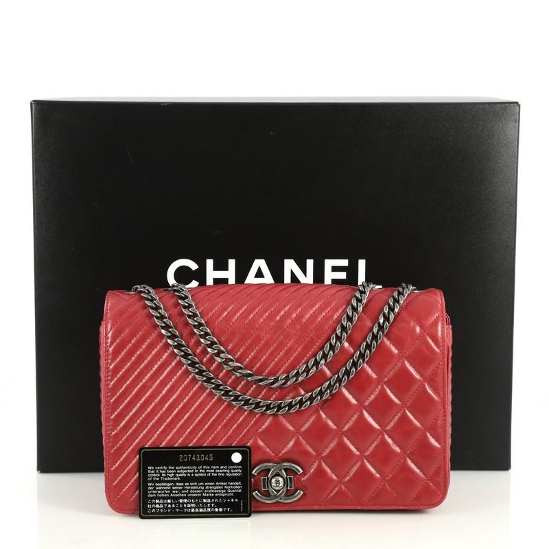 This Chanel Coco Boy Flap Bag Quilted Aged Calfskin Medium, crafted from red quilted aged calfskin leather, features woven-in leather chain strap and aged silver-tone hardware. Its CC boy push-lock closure opens to a red fabric interior with zip