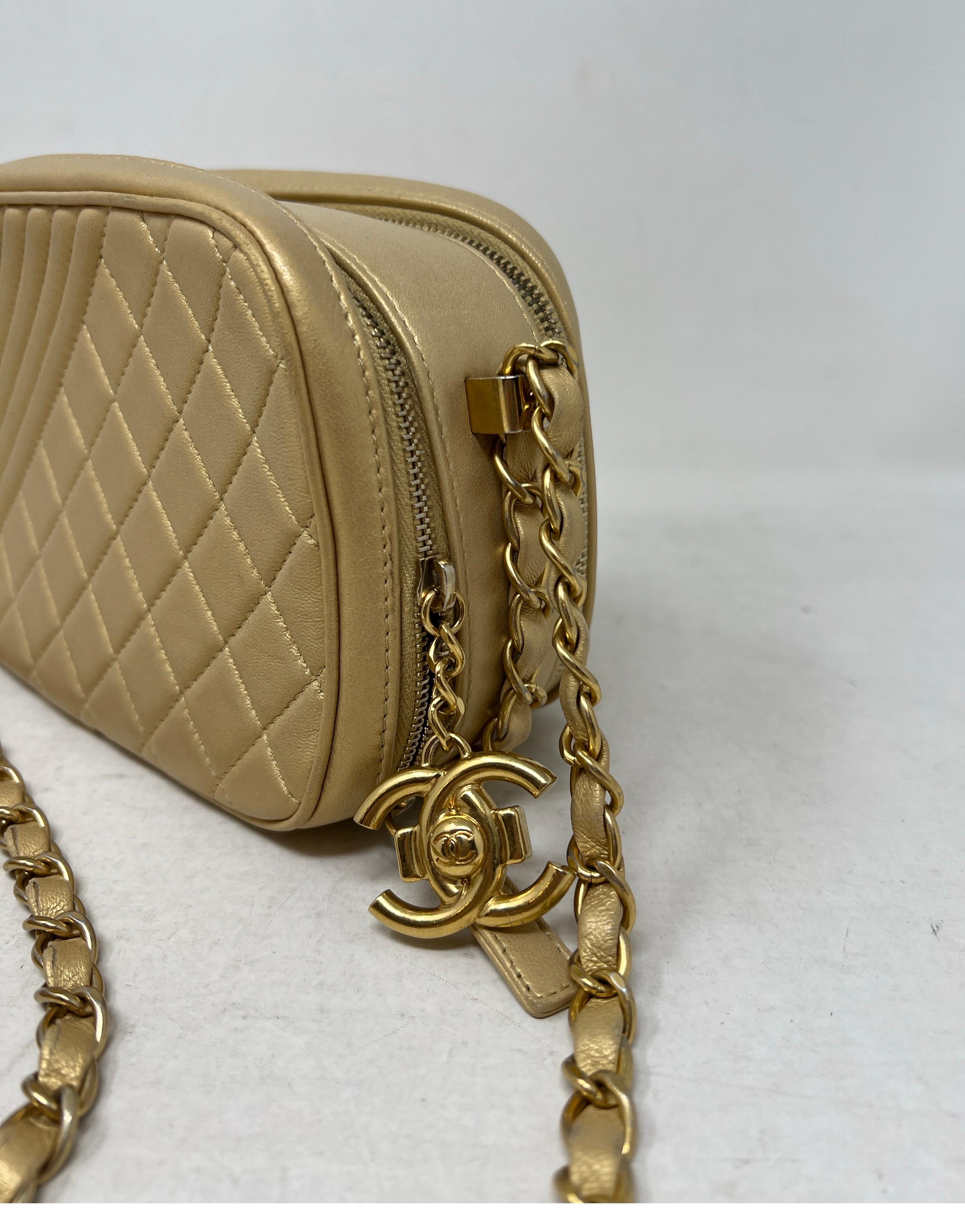 Chanel Coco Boy Camera Case Bag. Gold metallic lambskin leather. Gold hardware. Excellent condition. The perfect size for a crossbody bag. Interior clean. Great looking bag for evening too. Priced to sell. Collector's piece. Serial number inside