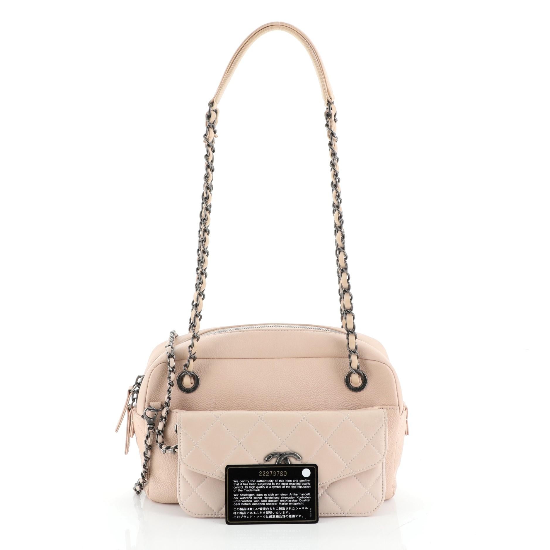 This Chanel Coco Break Camera Case Caviar Medium, crafted in pink caviar leather, features dual woven in leather chain link straps with leather pads, front quilted lambskin insert with CC logo, and aged silver-tone hardware. Its zip closure opens to